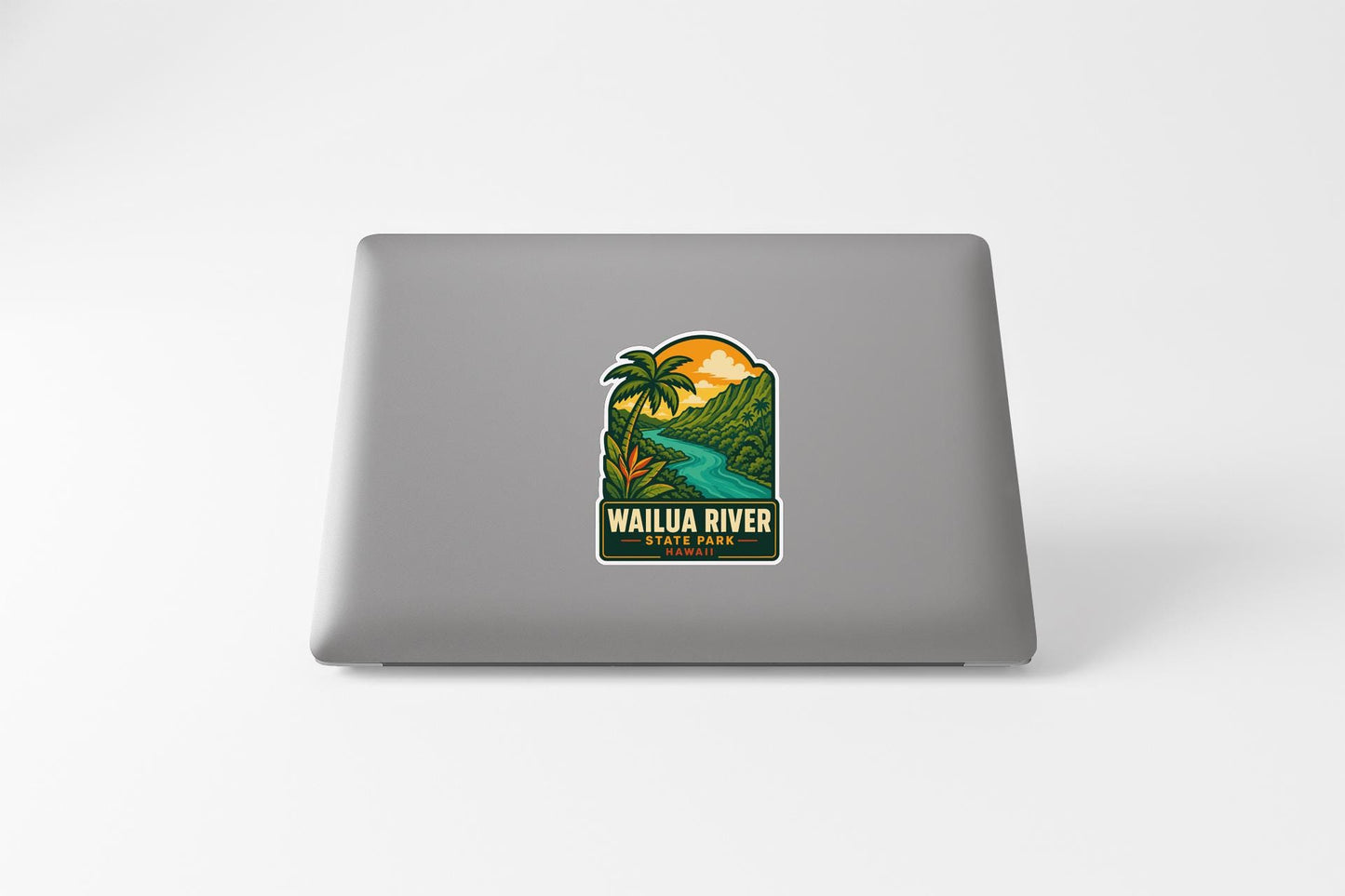 A sticker on the back of a laptop, depicting a tropical landscape with a river and palm trees.