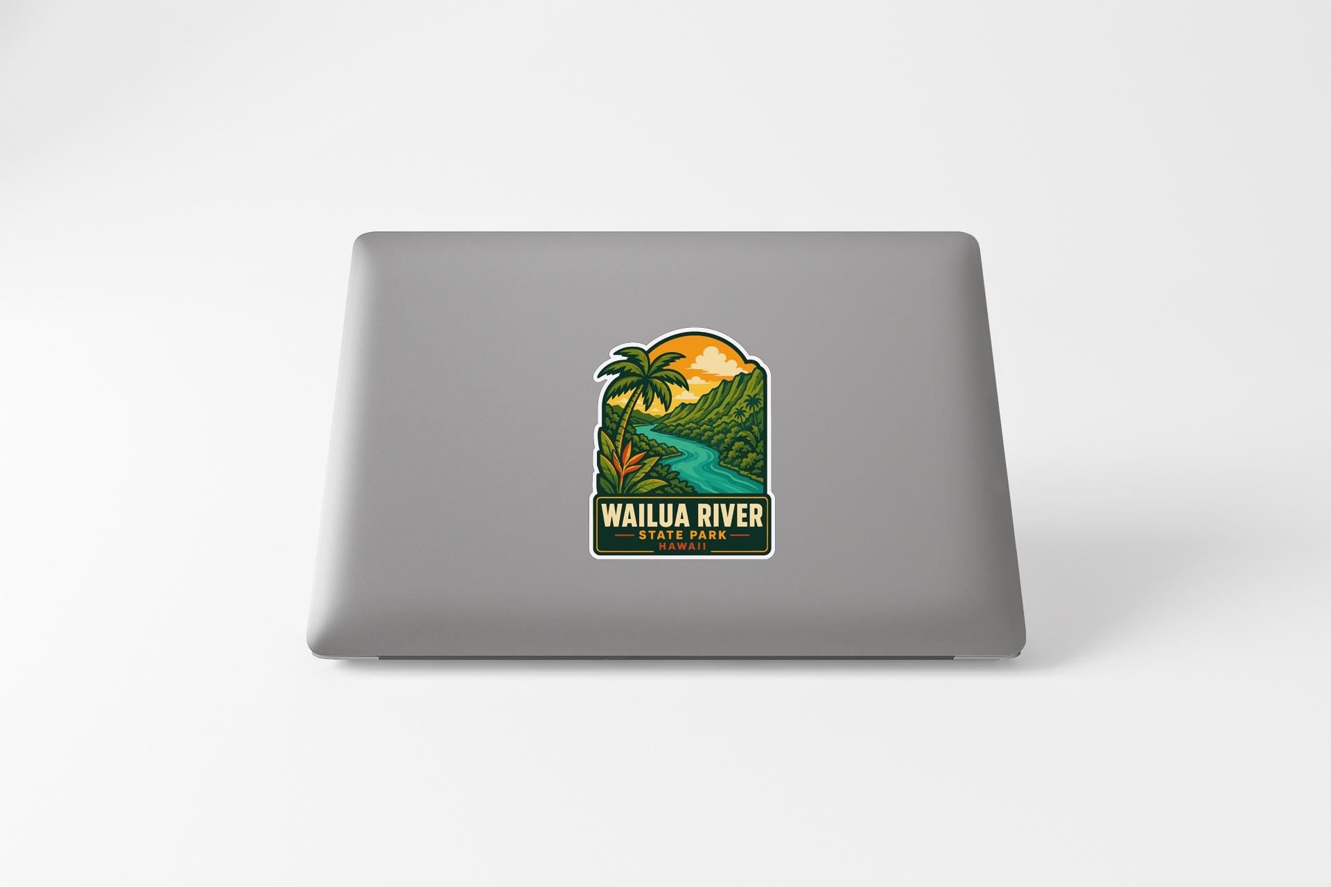 A sticker on the back of a laptop, depicting a tropical landscape with a river and palm trees.