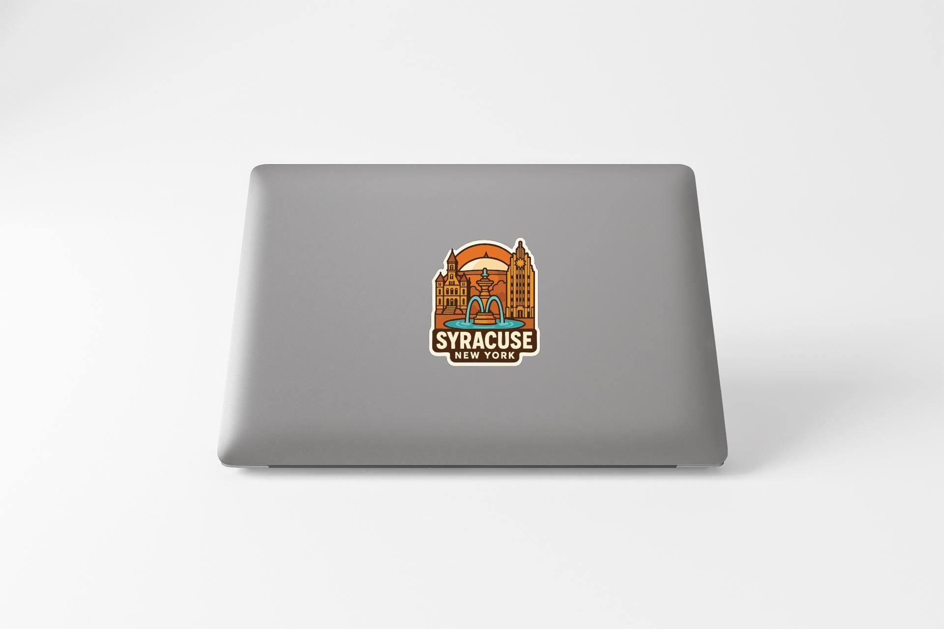 A sticker on the back of a laptop displaying the text "SYRACUSE NEW YORK" along with an illustration of a city skyline.