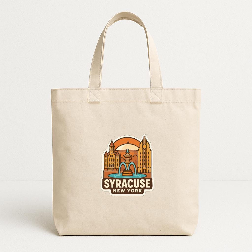 A beige tote bag with a printed design of a city skyline and the text "SYRACUSE NEW YORK" on it.