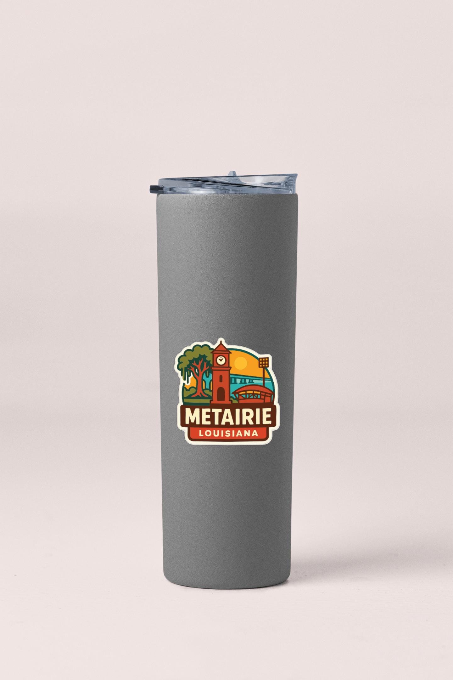 A gray insulated tumbler with a logo that says "METAIRIE LOUISIANA".