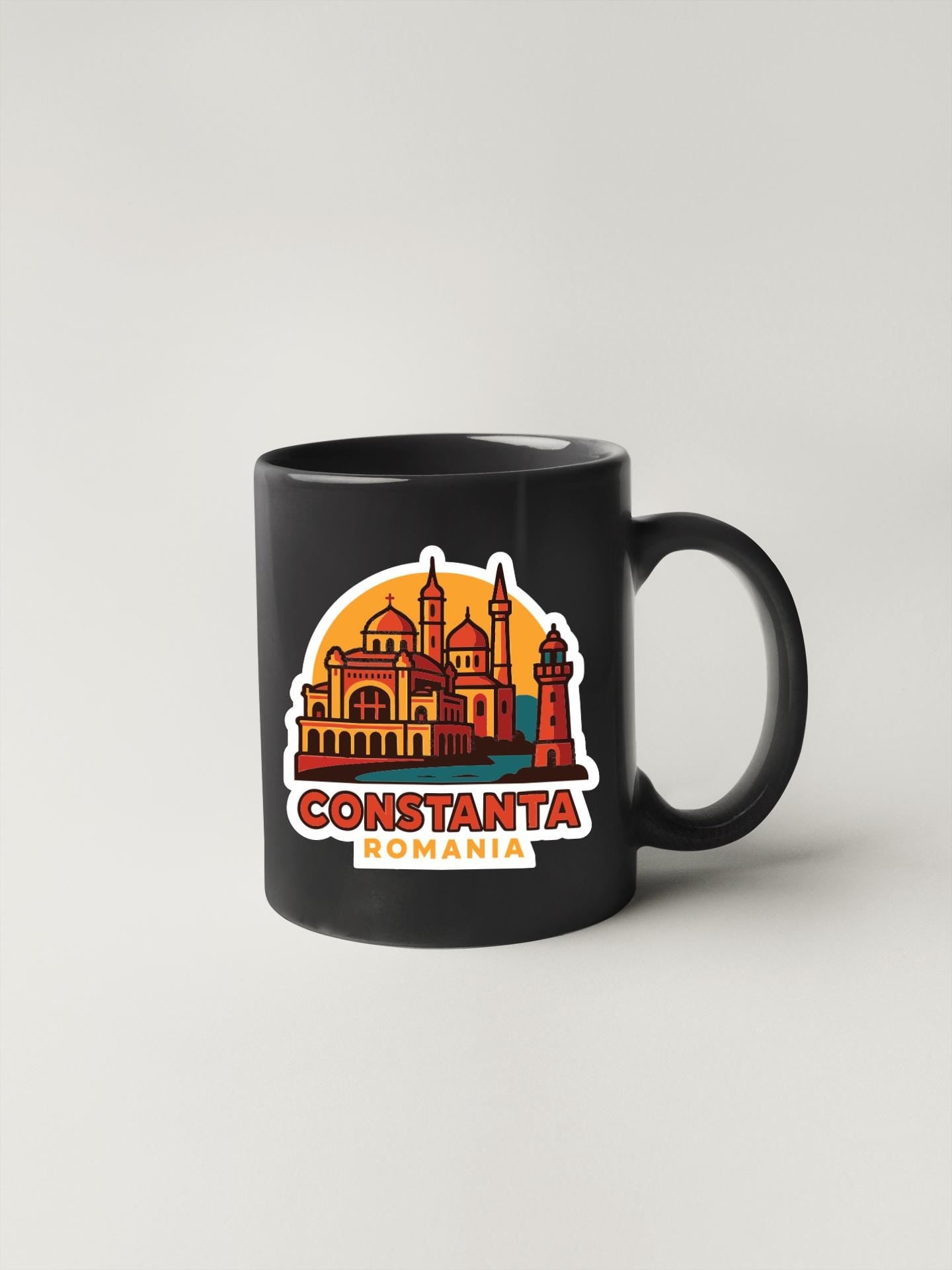 A black coffee mug with a colorful illustration of the city of Constanta, Romania, featuring a castle and lighthouse.