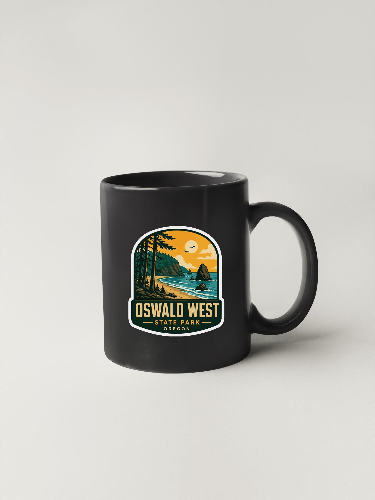 A black coffee mug with a graphic design depicting a scenic landscape, including a sunset, mountains, and a body of water.