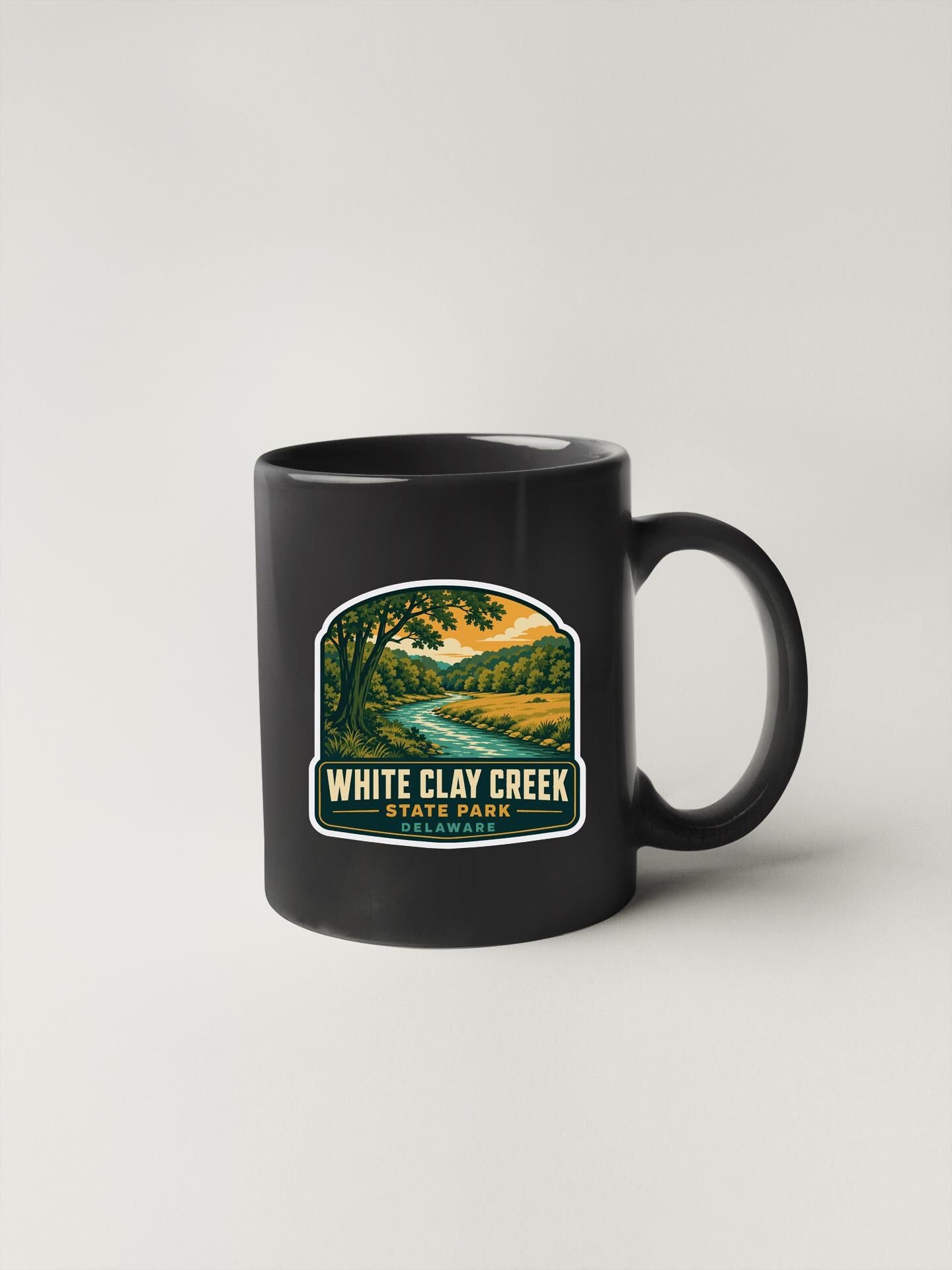 A black coffee mug with a label that says "WHITE CLAY CREEK STATE PARK".