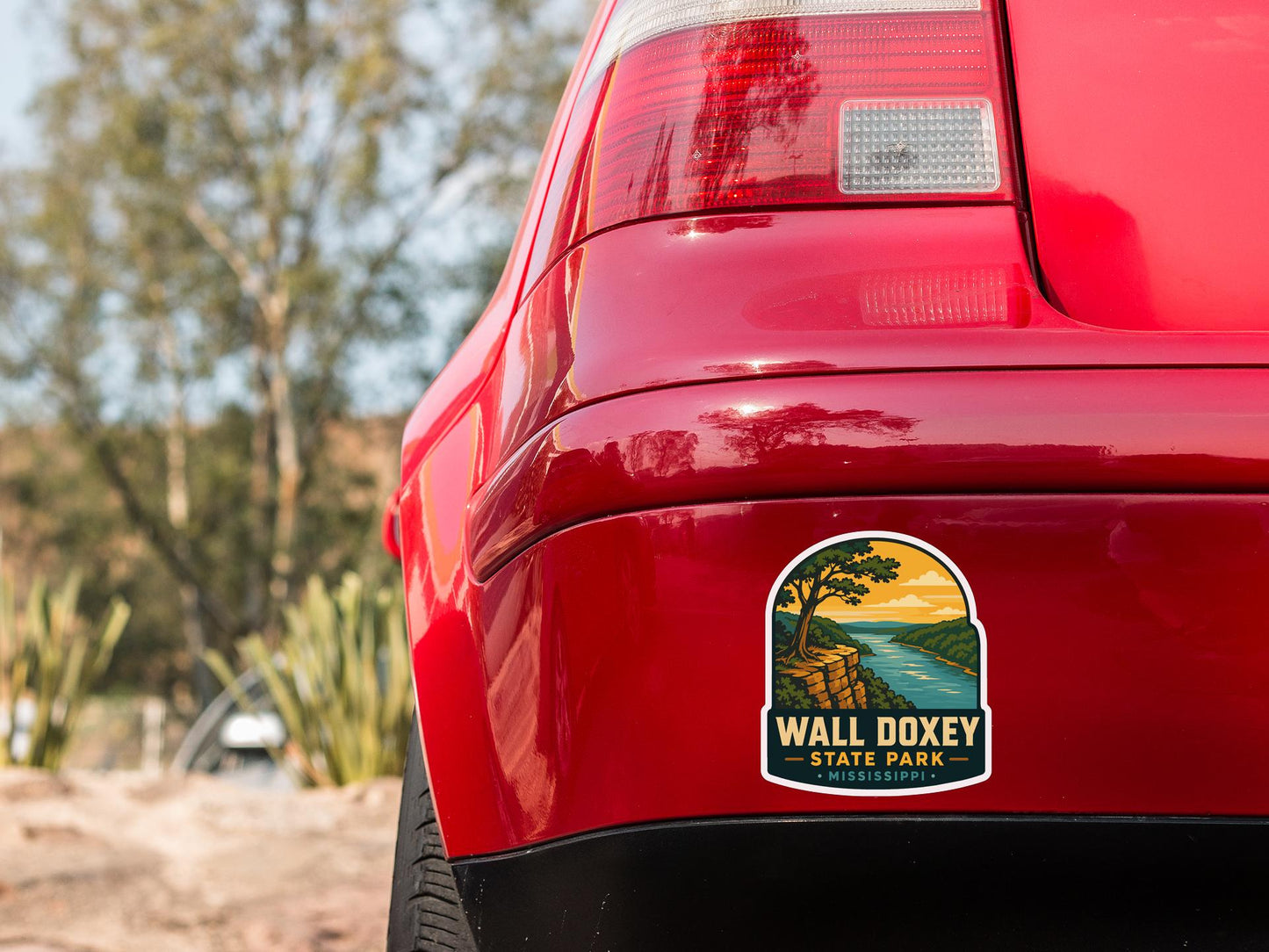the rear end of a red car with a sticker on the trunk that says "Wall Dooley State Park - Mississippi".