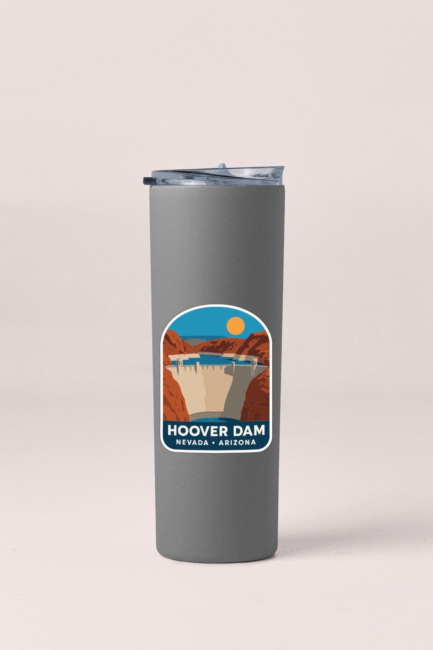 A gray insulated tumbler with a sticker depicting the Hoover Dam in Nevada, Arizona.