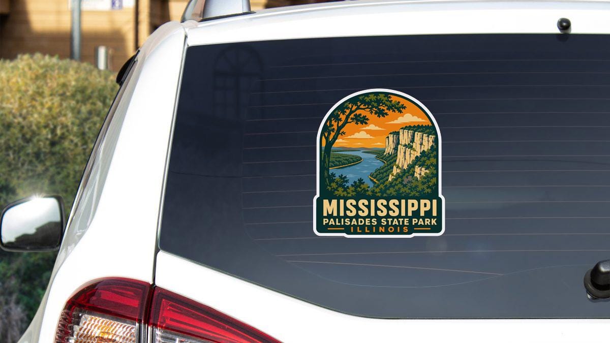 A sticker on the rear window of a white vehicle, depicting a scenic landscape with mountains, a river, and a sunset.