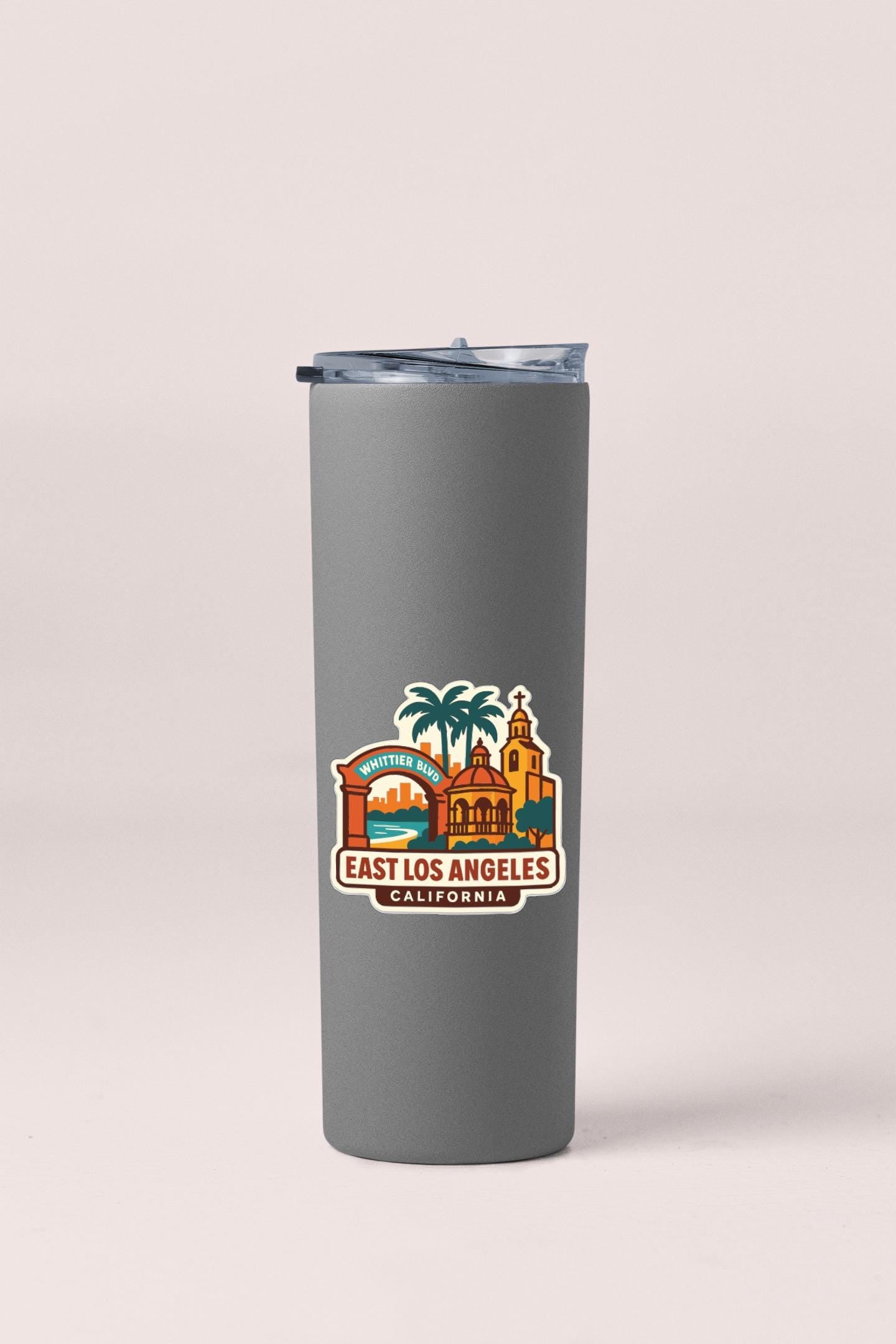A gray insulated tumbler with a printed design of landmarks and text that says "EAST LOS ANGELES, CALIFORNIA".