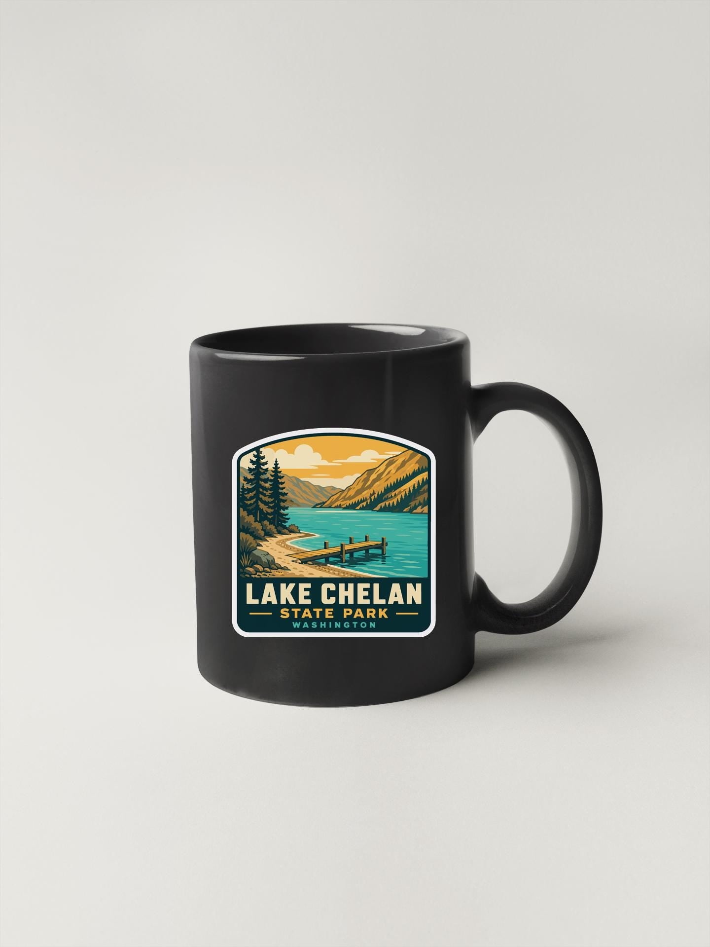 A black coffee mug with a printed design depicting a scenic landscape with a lake, mountains, and a boat on the water.