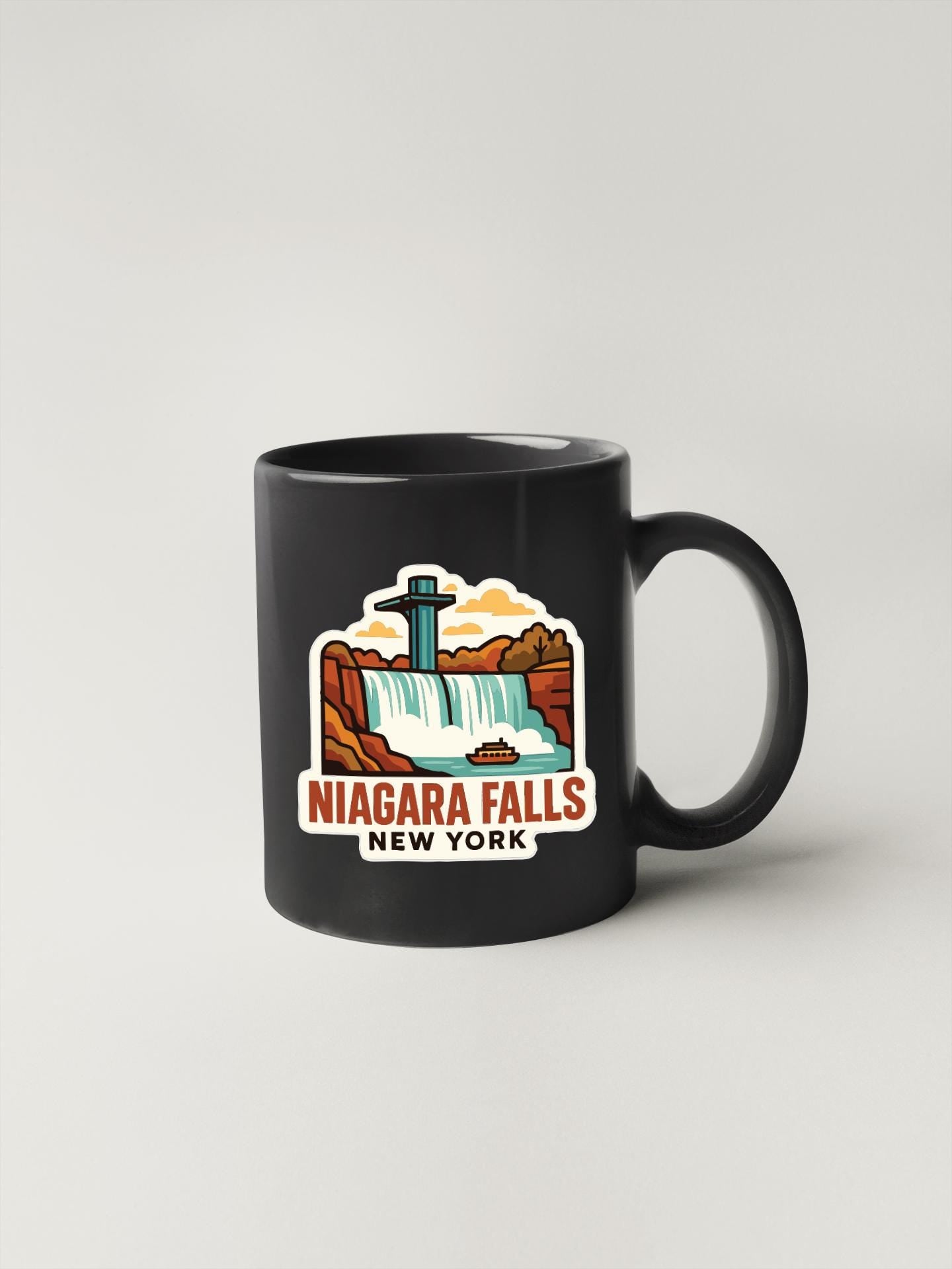 A black coffee mug with a colorful illustration of Niagara Falls and the text "Niagara Falls New York" printed on it.