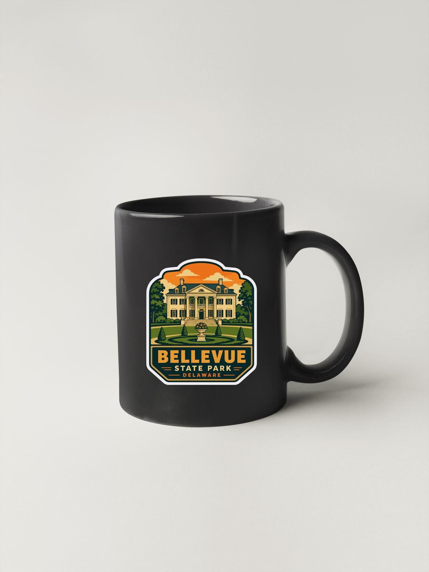 A black coffee mug with a graphic design depicting a building and trees, along with the text "Bellevue State Park".
