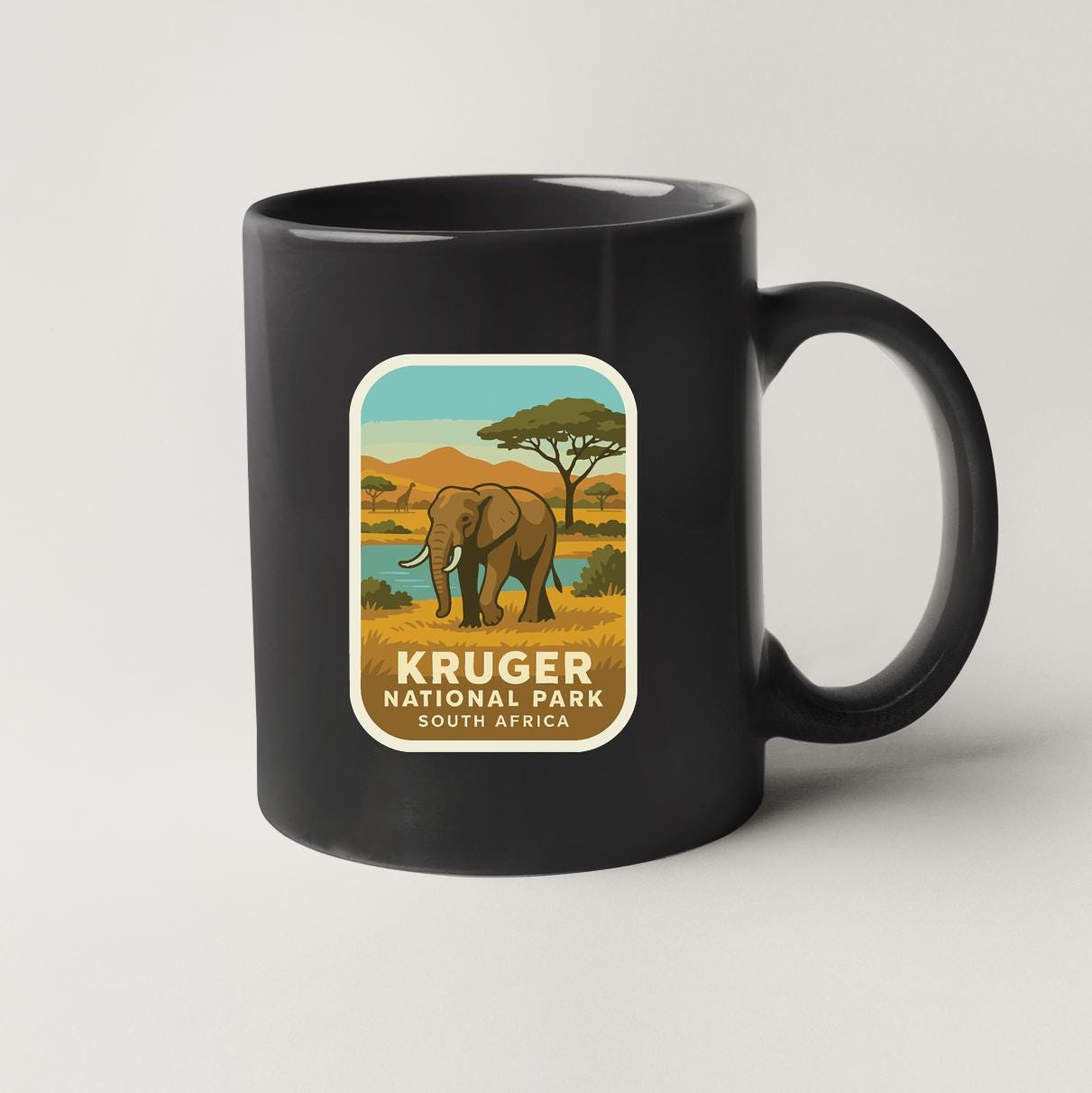 A black coffee mug with a graphic of an elephant and the text "KRUGER NATIONAL PARK SOUTH AFRICA" printed on it.