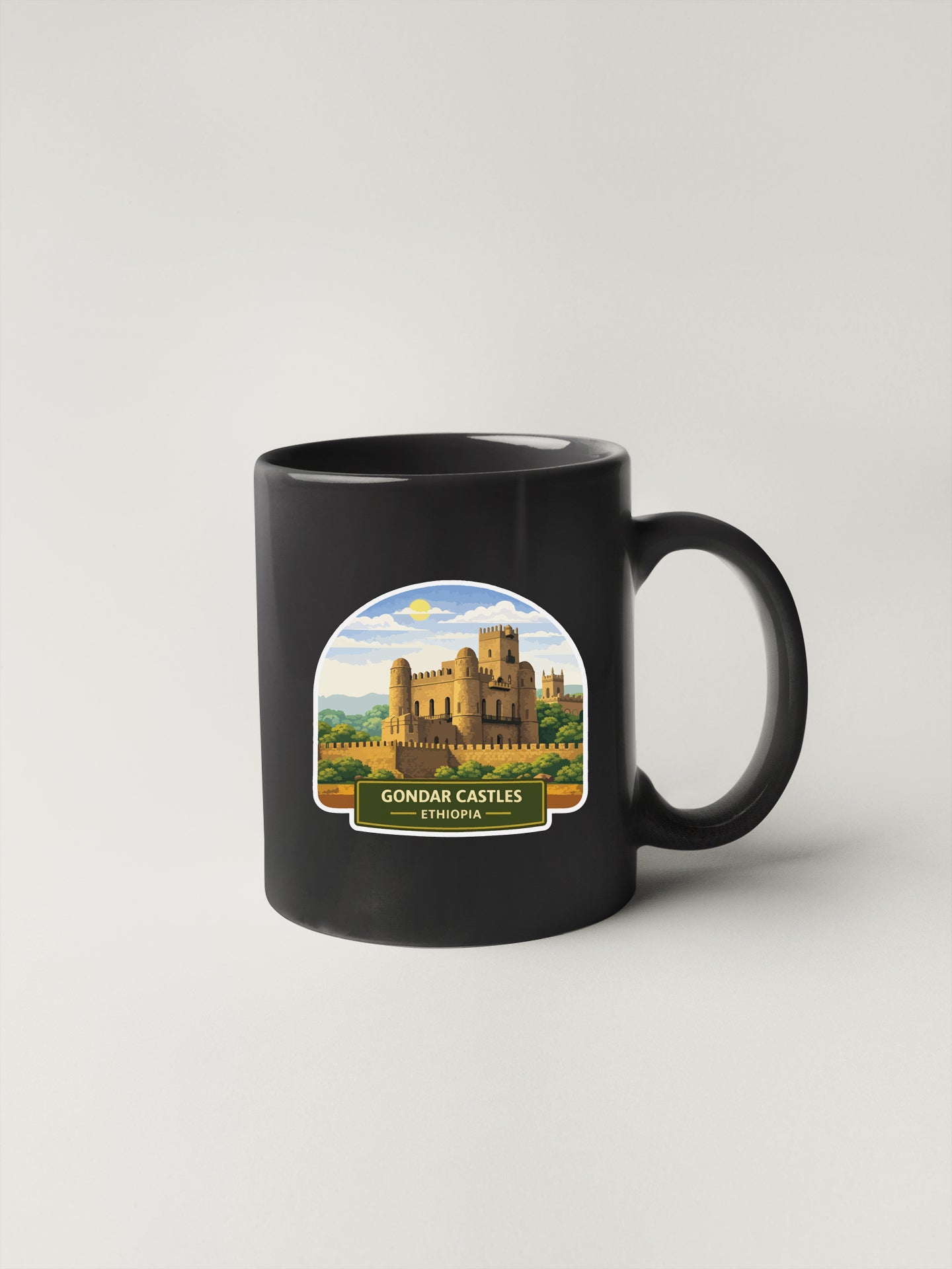 A black coffee mug with a sticker depicting the Gondar Castle in Ethiopia.
