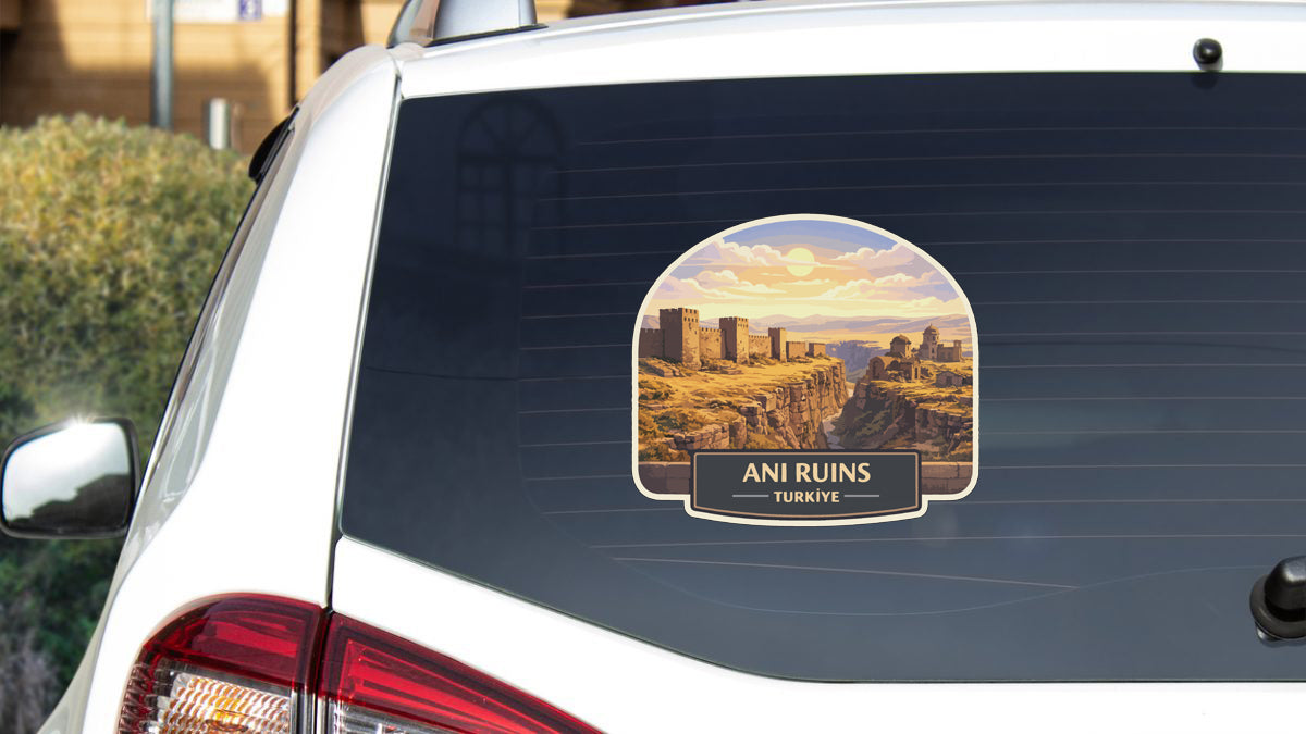 a sticker on the rear window of a car that displays a scenic landscape with a desert and mountains.