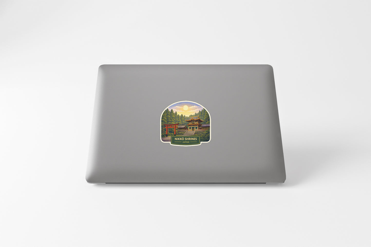 a sticker on the back of a laptop, depicting a scenic landscape with a cabin in the background.