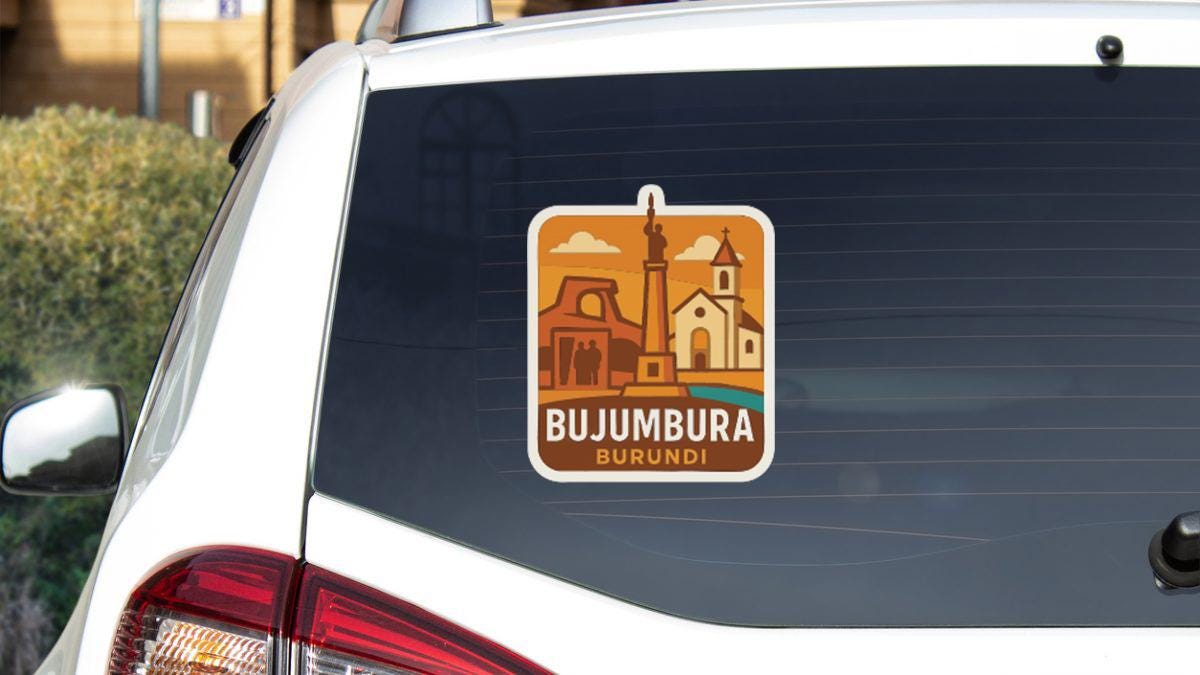 A sticker on the rear window of a white car, depicting a cityscape with a tall building and a church.
