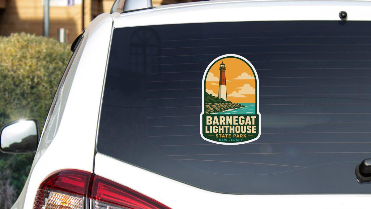 A sticker on the rear window of a white car, depicting the Barnesat Lighthouse in New Jersey.