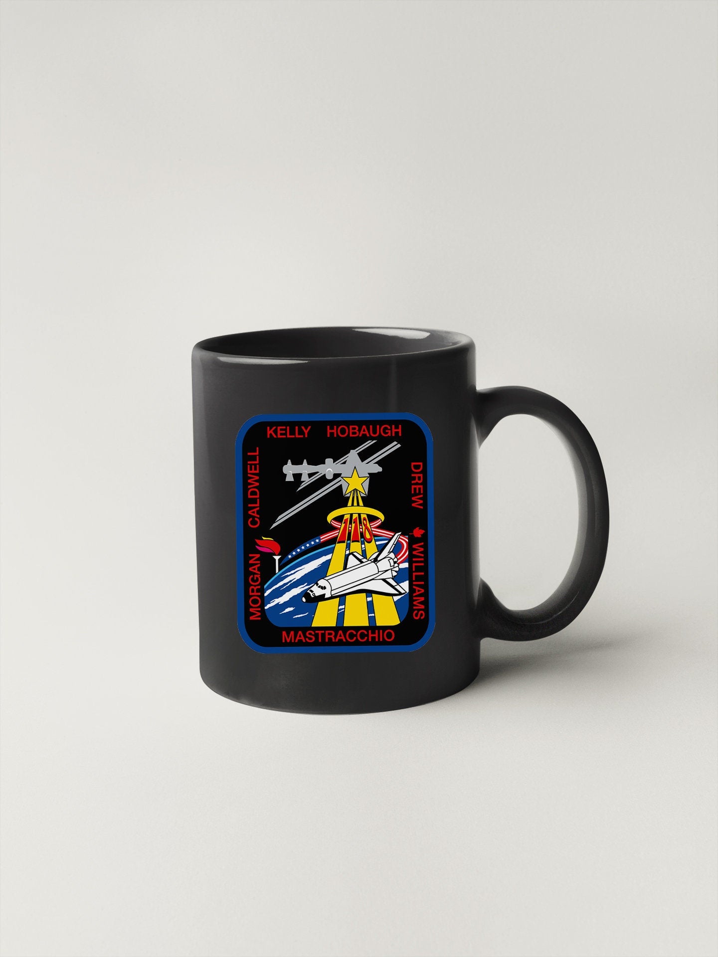 a black coffee mug with a space shuttle on it