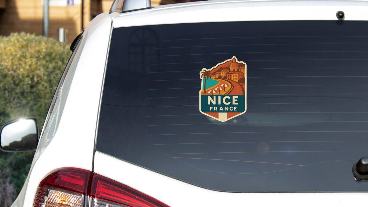 the rear window of a white car with a sticker on it.