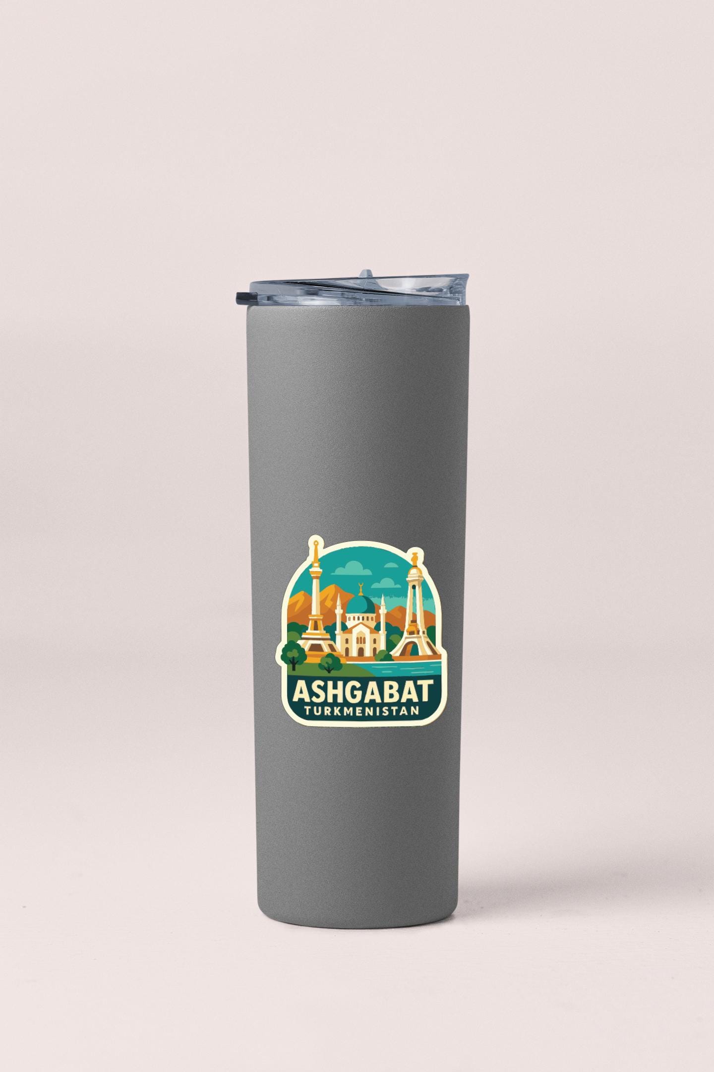 A gray insulated tumbler with a sticker depicting the city of Ashgabat, Turkmenistan.