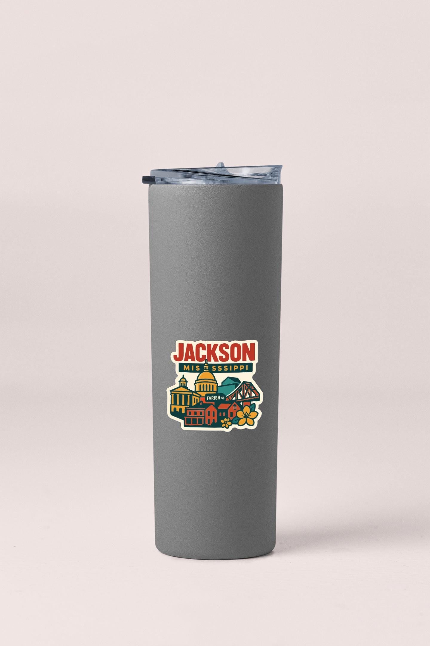 A gray insulated tumbler with a colorful sticker depicting a cityscape and the text "JACKSON" printed on it.