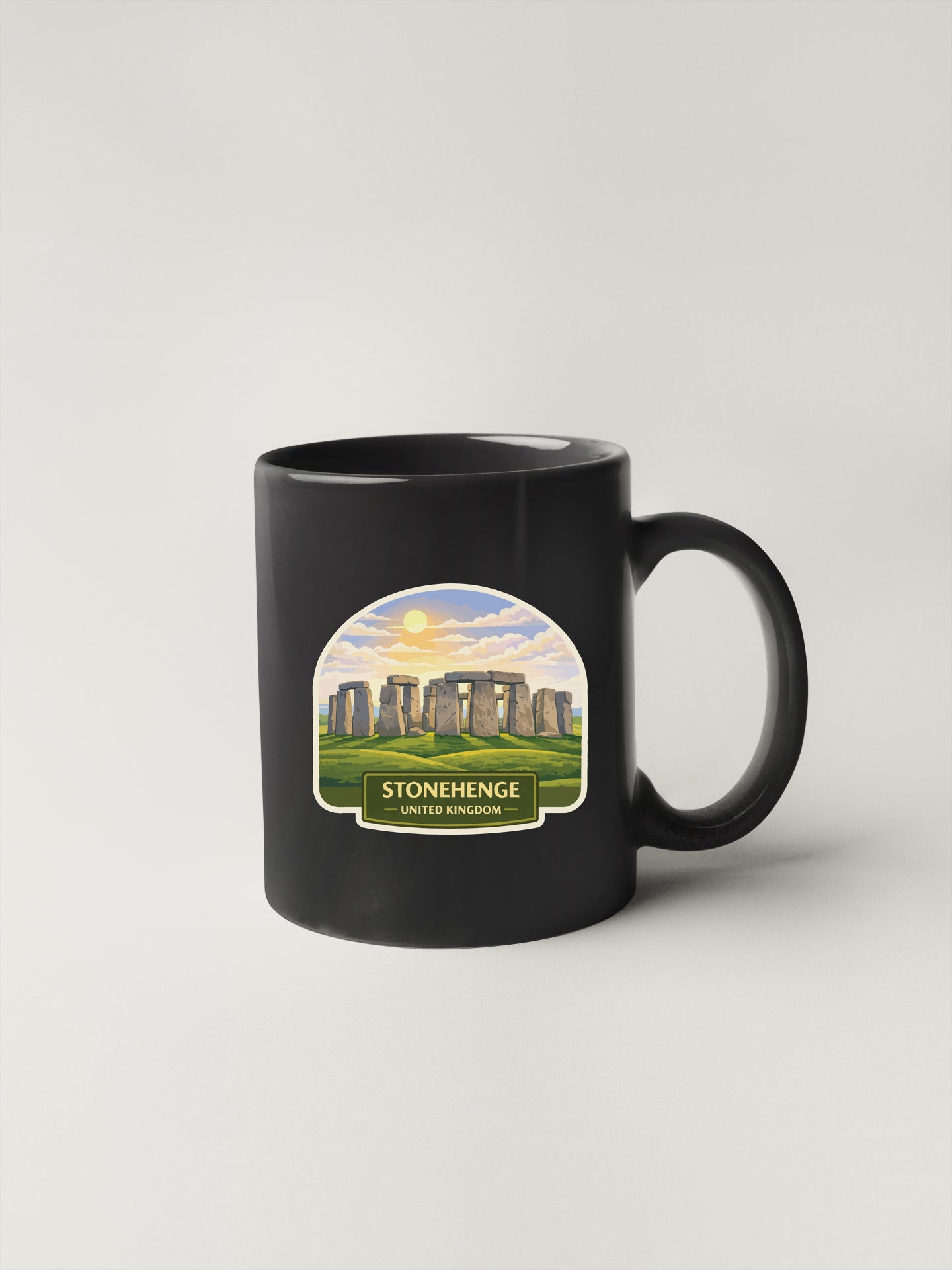 A black coffee mug with a label that says "STONEHENGE UNITED KIRKLAND" and features an illustration of Stonehenge in the background.