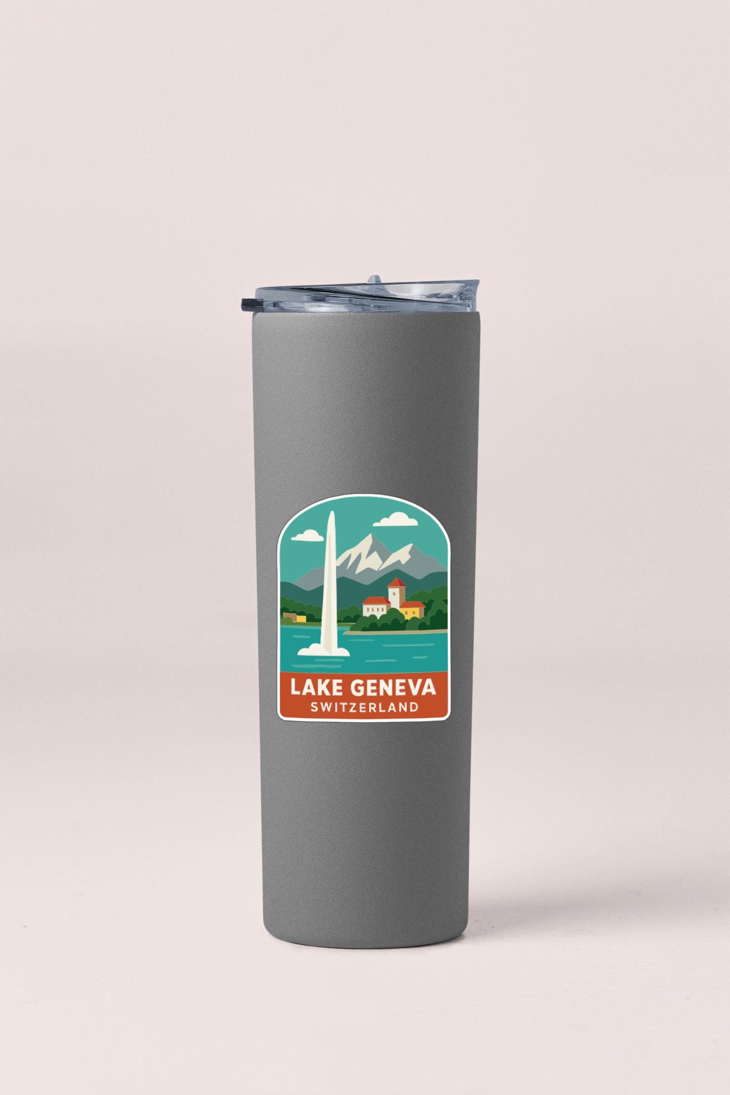A gray insulated tumbler with a sticker depicting Lake Geneva, Switzerland.