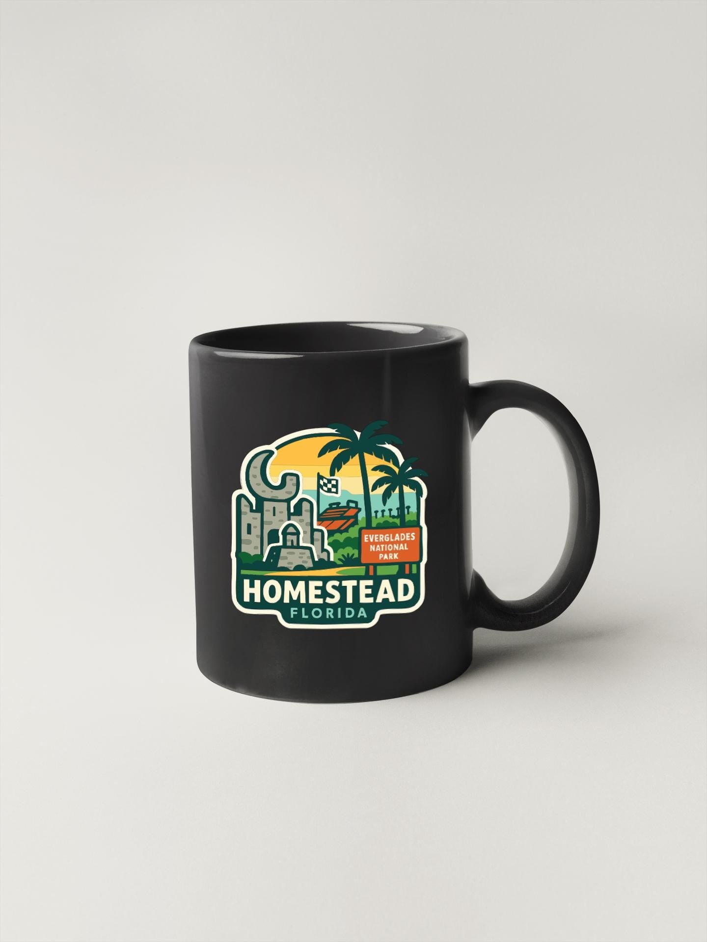 A black coffee mug with a graphic design depicting a tropical landscape, including palm trees, buildings, and a sunset.