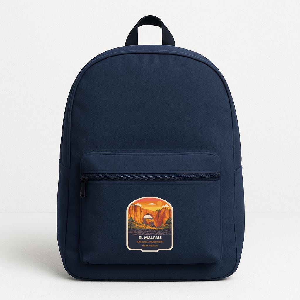 A navy blue backpack with a graphic of a desert landscape and the text "EL MALPAIS" printed on it.