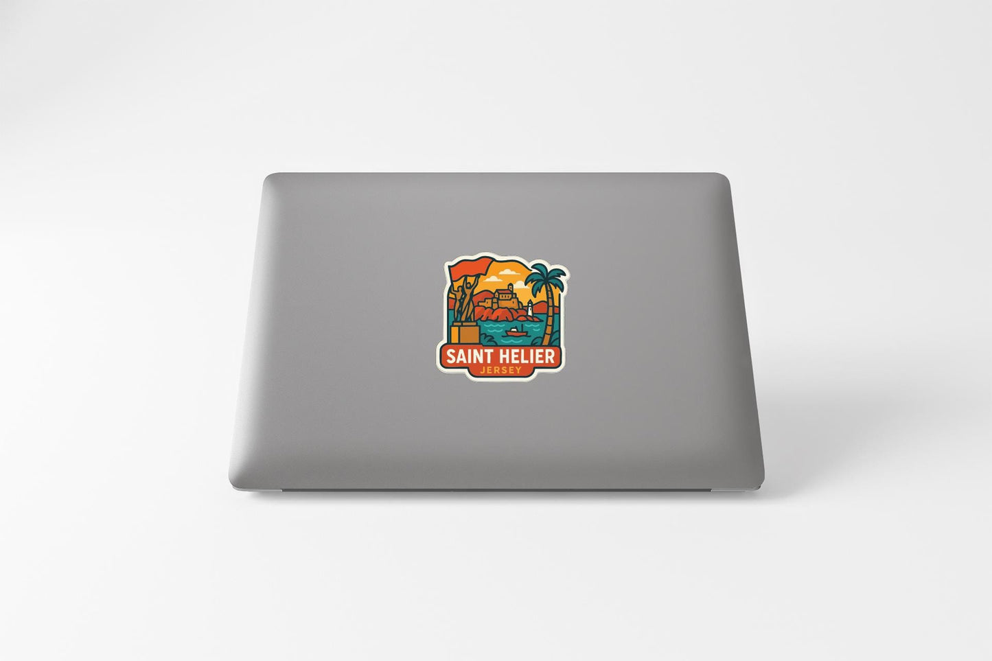 a sticker on the back of a laptop with a tropical beach scene and the text "SANT HELIER" printed on it.