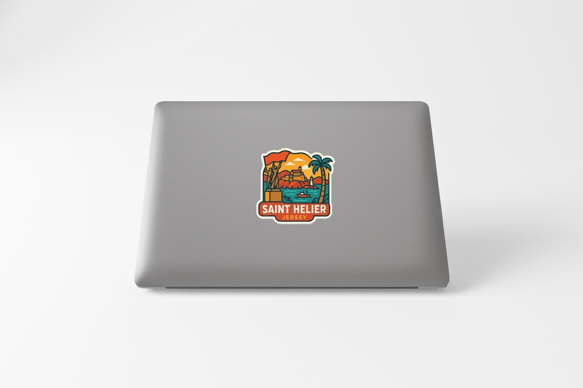 a sticker on the back of a laptop with a tropical beach scene and the text "SANT HELIER" printed on it.