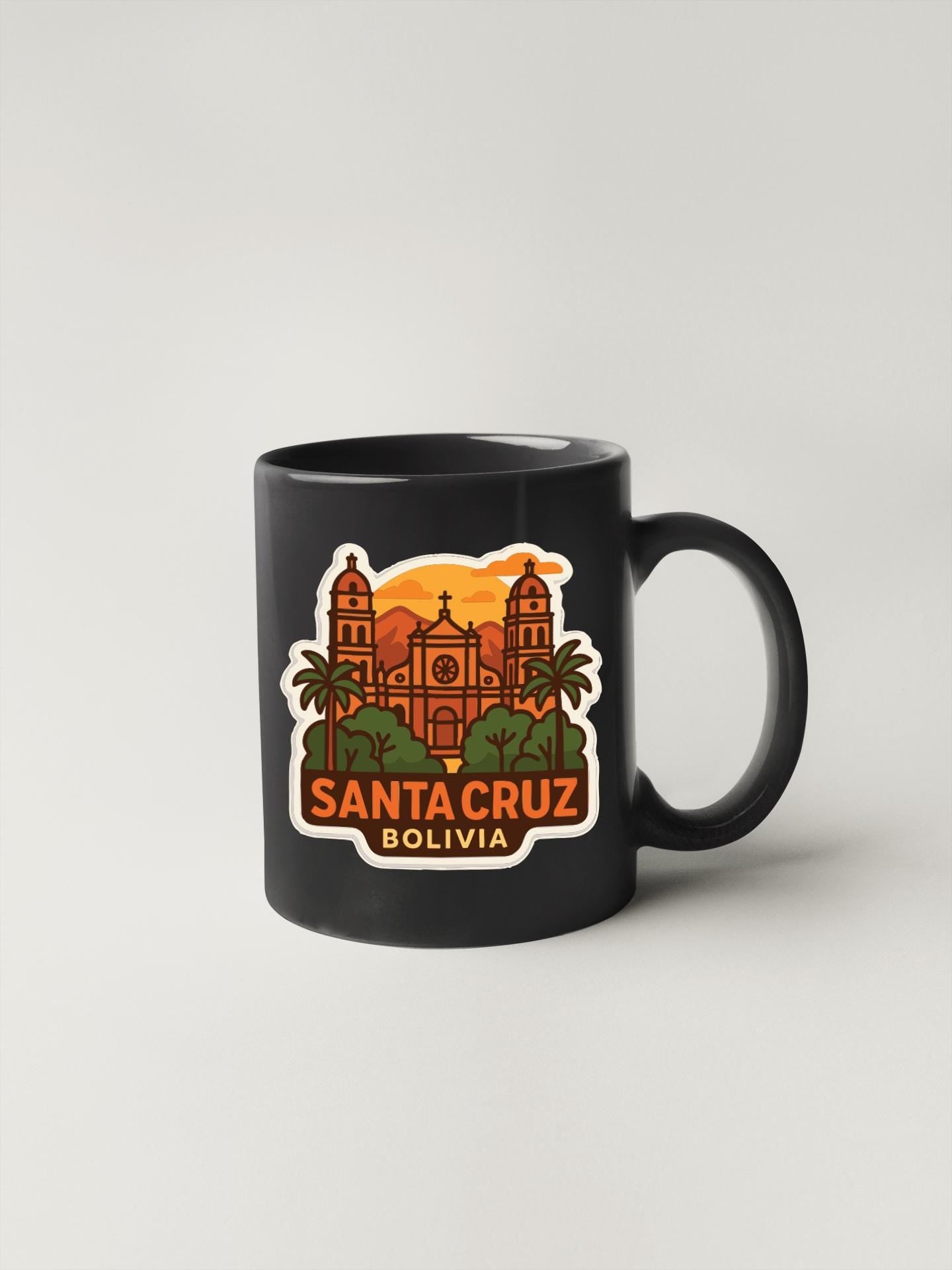 A black coffee mug with a sticker depicting the Santa Cruz Cathedral in Bolivia.