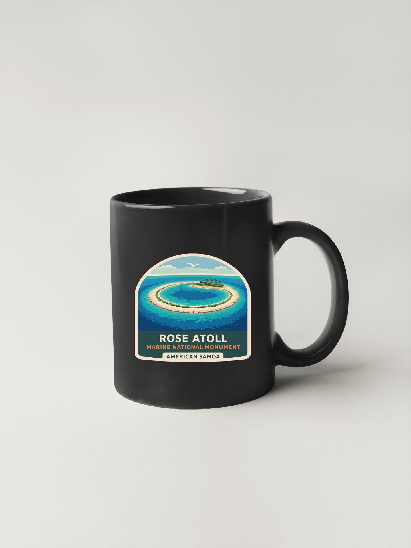 A black coffee mug with a label that says "ROSE ATOLL MARINE SANCTUARY AMERICAN SANCTUARY".