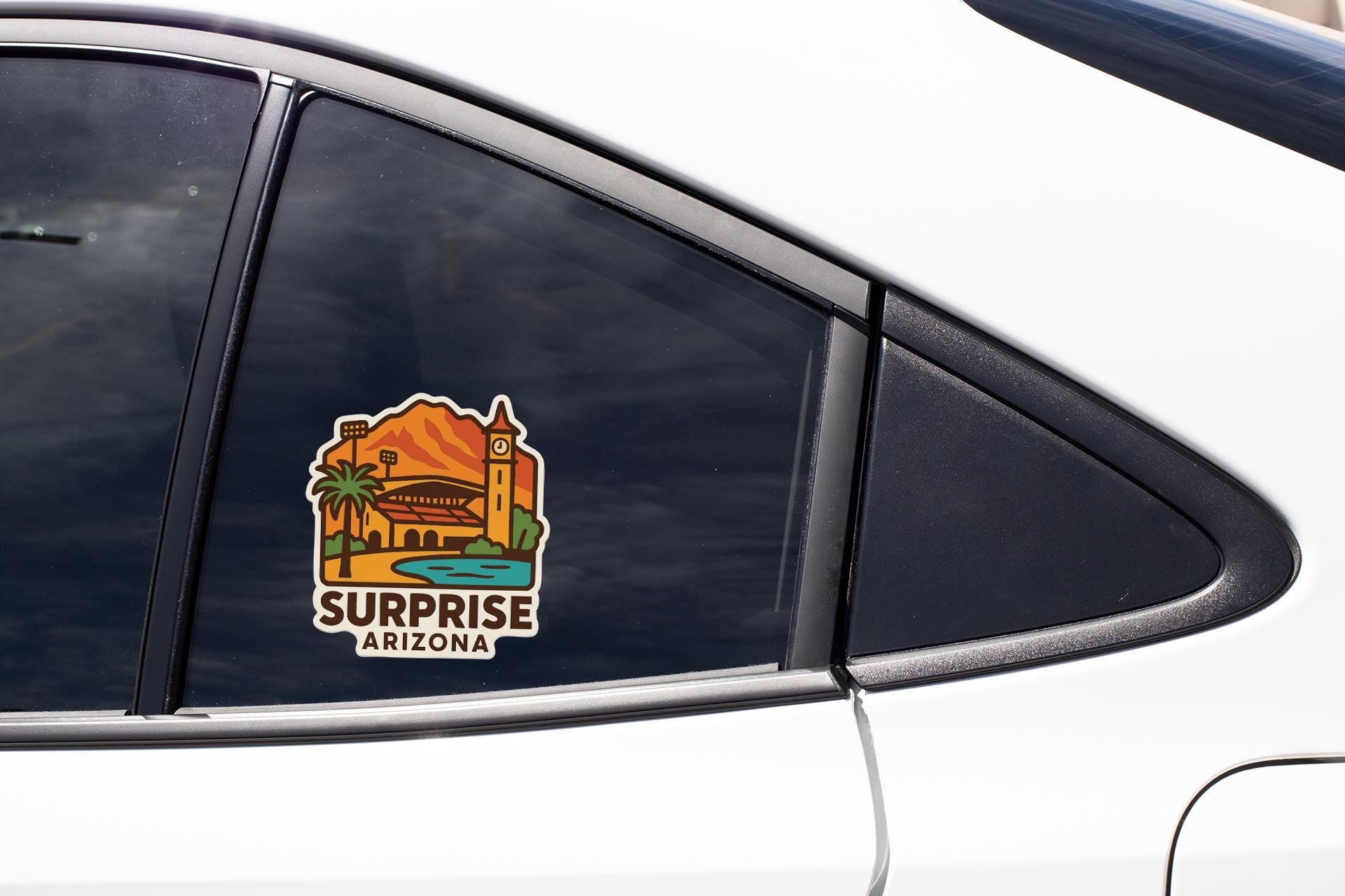A sticker on the side of a car window that says "Surprise Arizona".