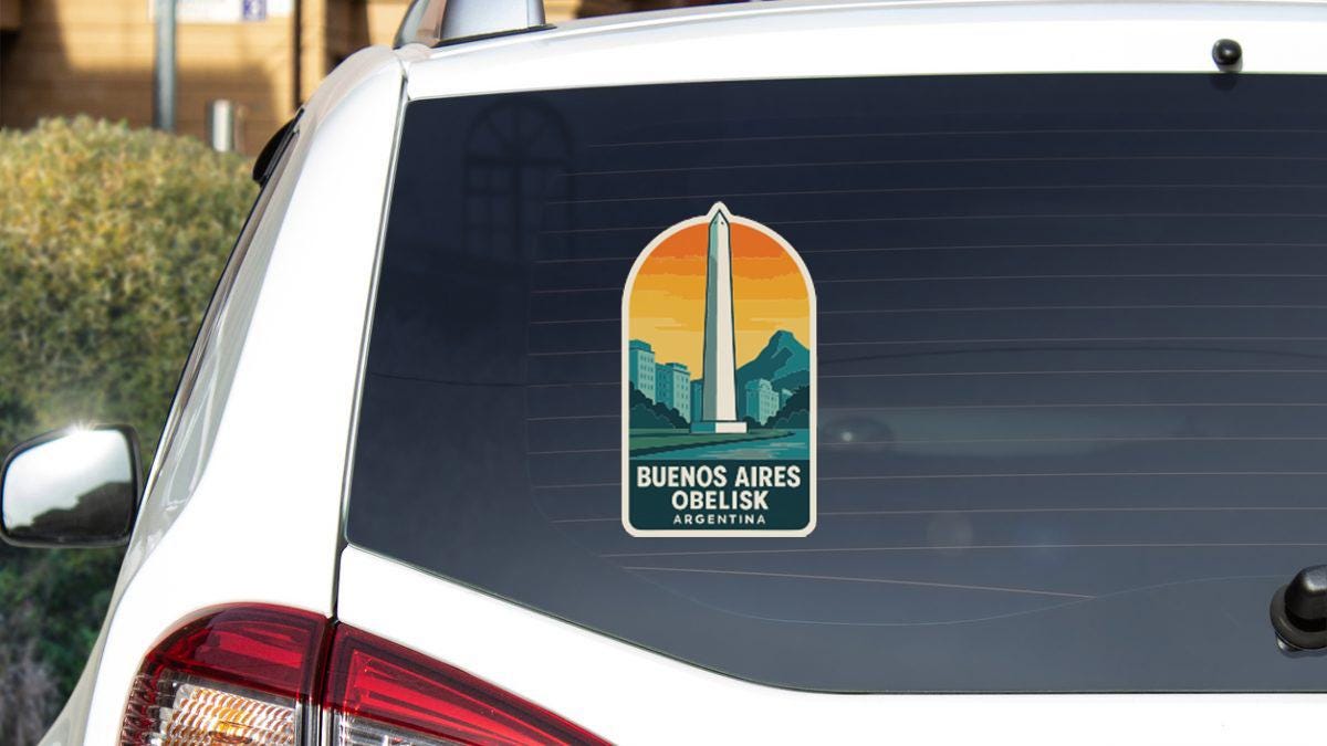 a sticker on the rear window of a white car, depicting the Washington Monument and displaying the text "BUENOS AIRES OBELIKA ARGENTINA".