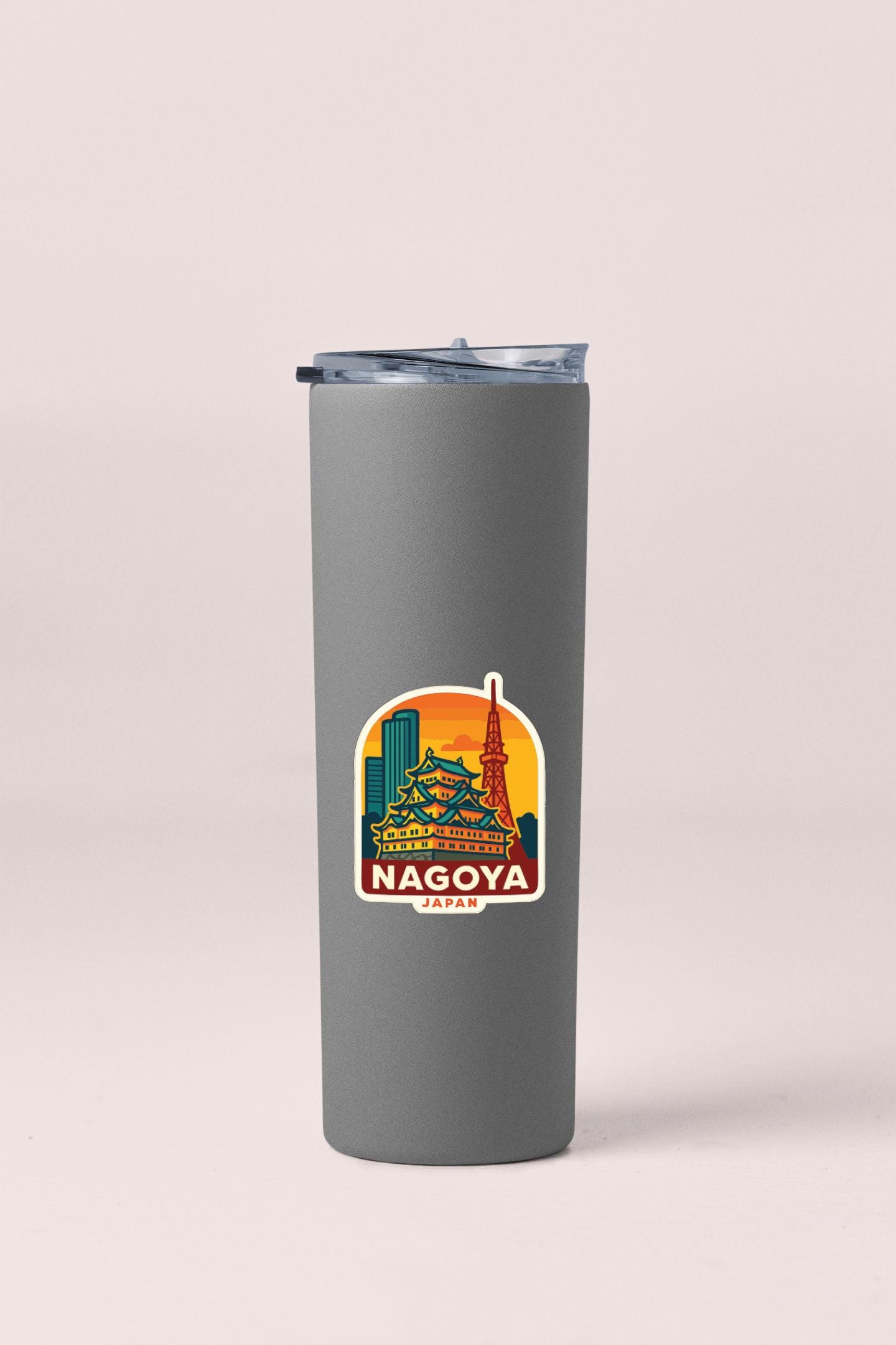 A gray insulated tumbler with a sticker depicting the Nagoya cityscape in Japan.