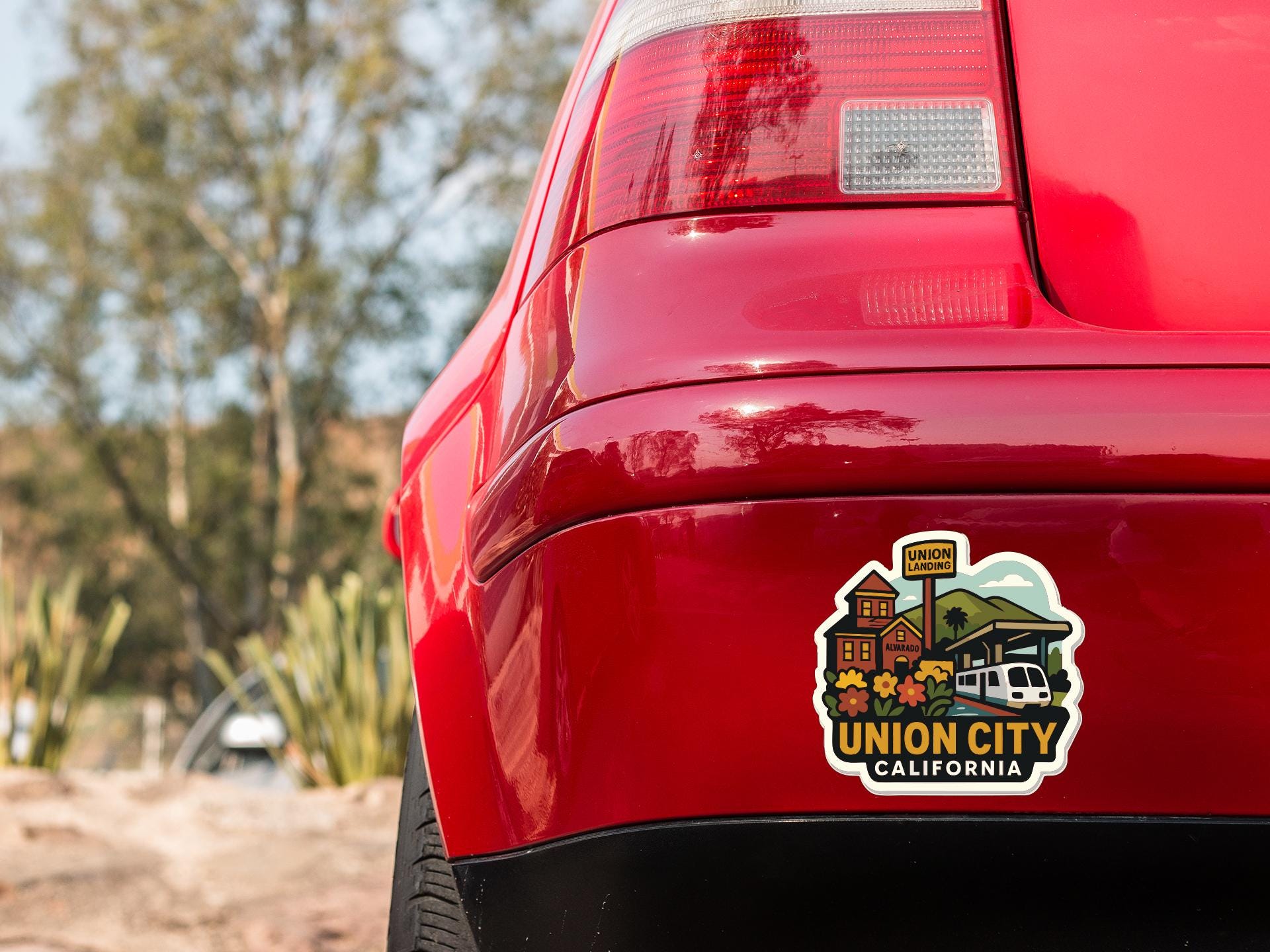 the rear end of a red car with a sticker on the trunk that says "UNION CITY CALIFORNIA".