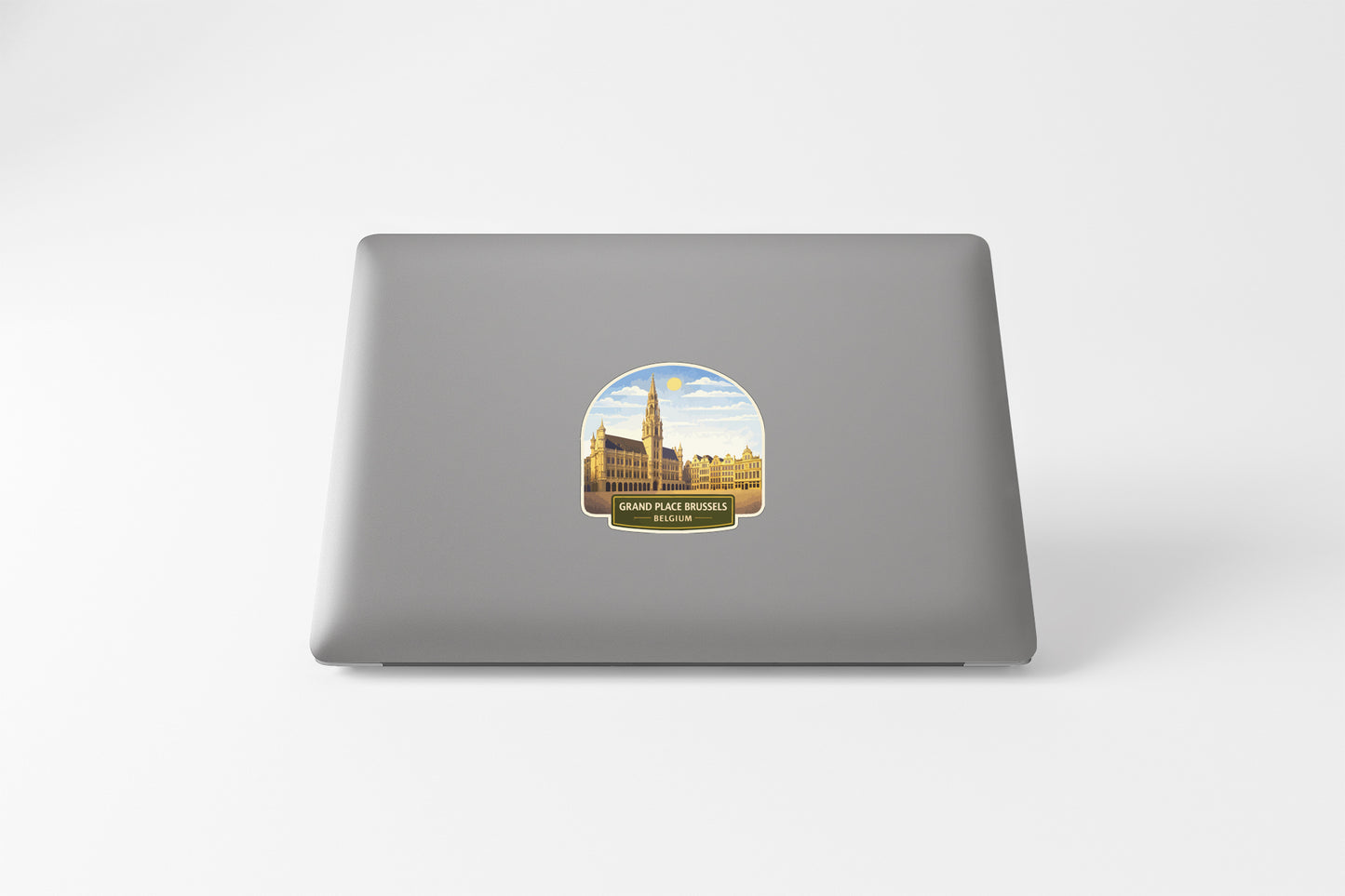 a sticker on the back of a laptop, depicting a cityscape with a tall building and a clock tower.