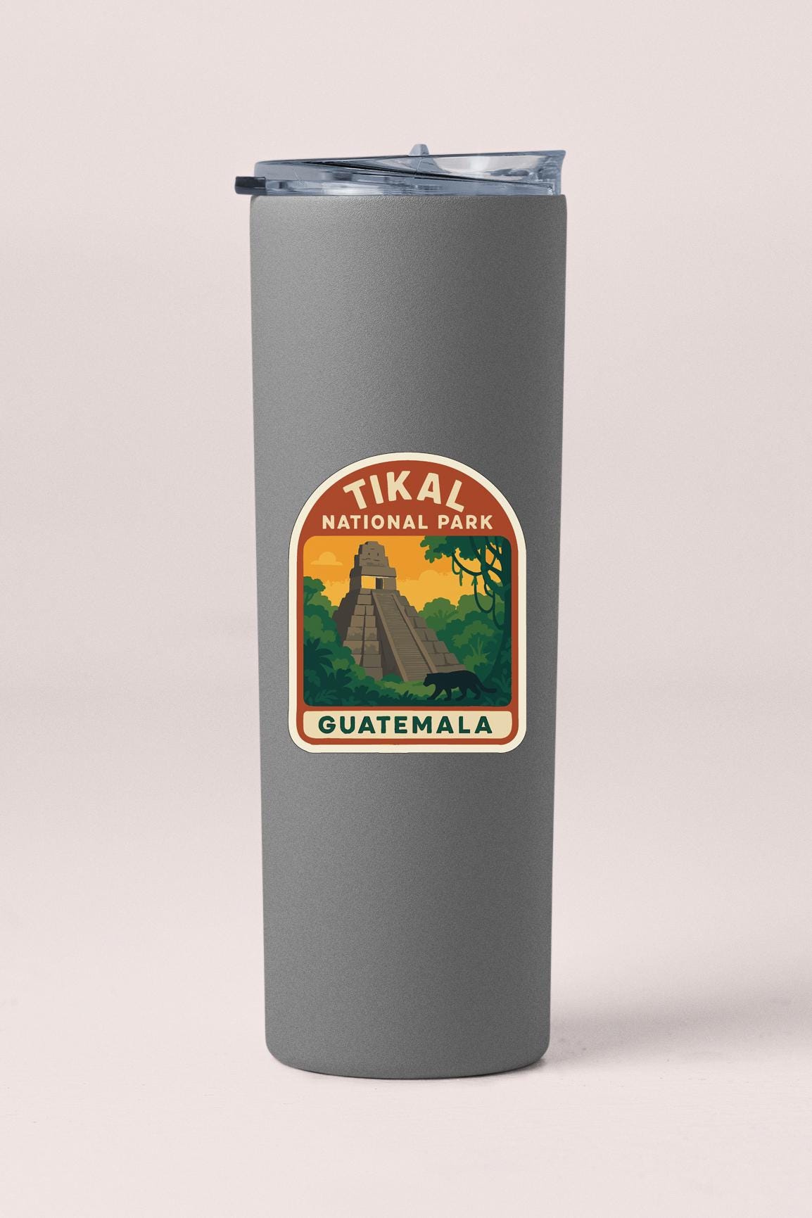 A gray tumbler with a sticker depicting the Tikal National Park in Guatemala.