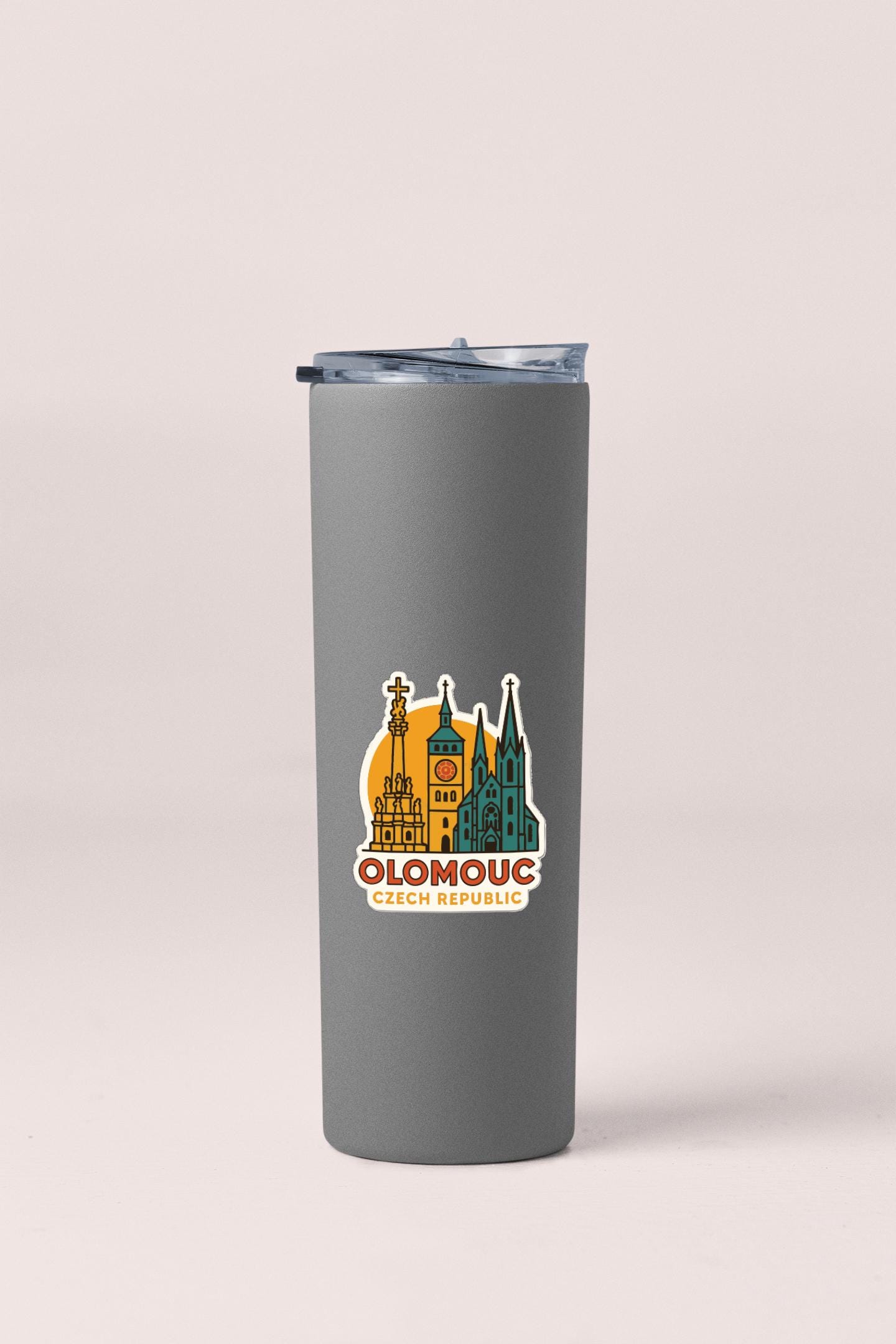 A gray insulated tumbler with a sticker depicting the cityscape of Prague, Czech Republic.