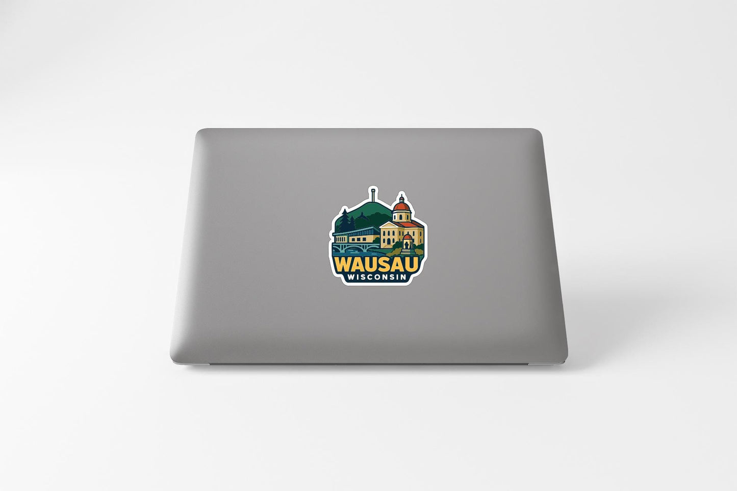 a sticker with a graphic of a building and the text "WASAU WISCONSIN" on the back of a laptop.