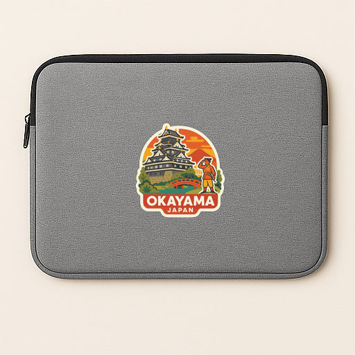 A gray laptop sleeve with a sticker depicting the Osaka Castle in Japan.