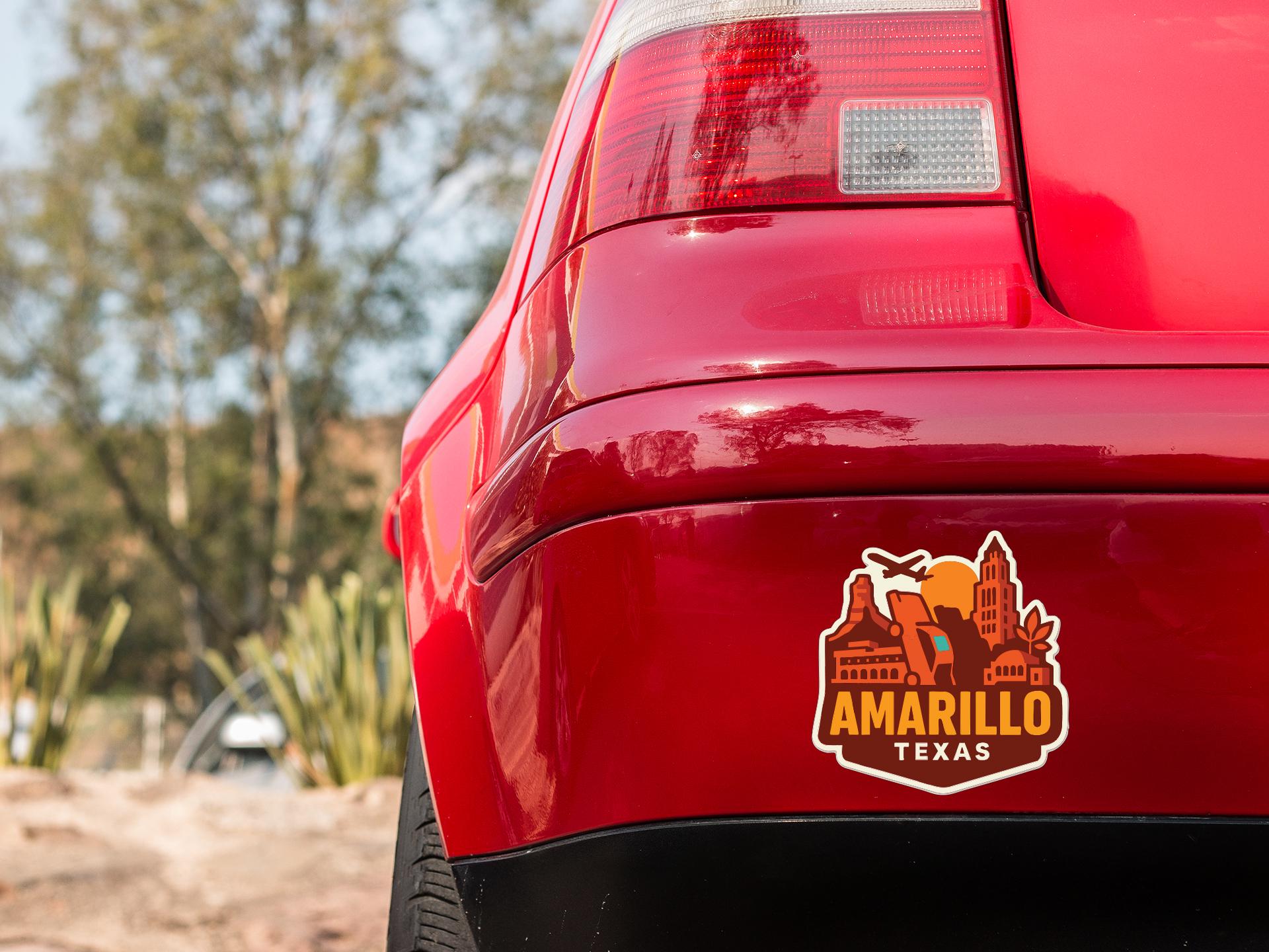 the rear end of a red car with a sticker on the trunk that says "AMARILLO TEXAS".