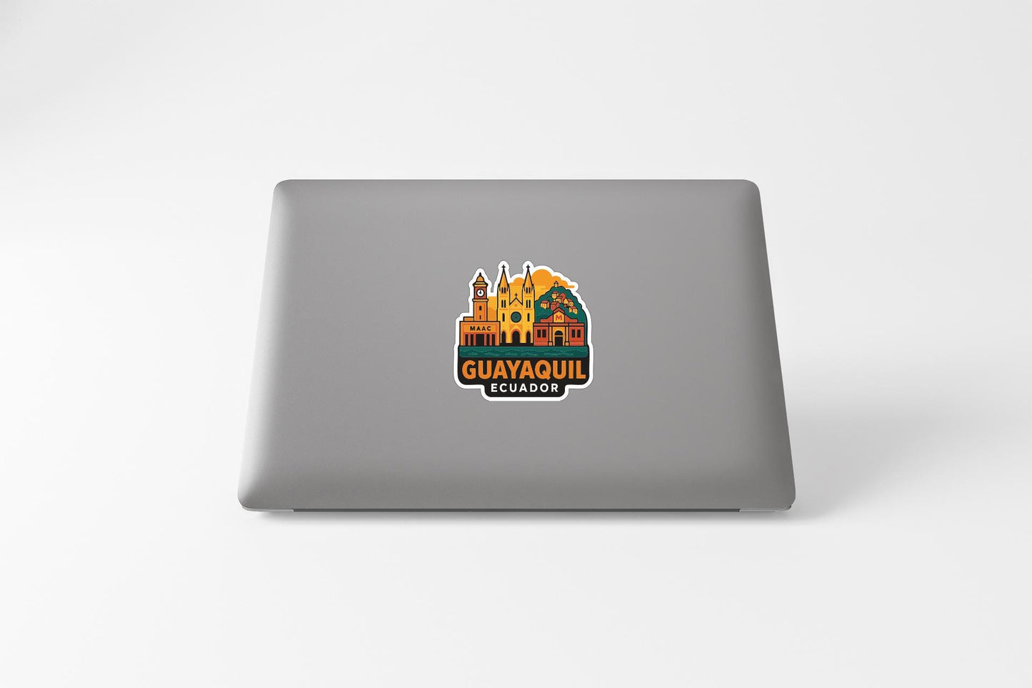 a sticker with a colorful illustration of a cityscape and the text "GUAYAQUI" on a laptop.