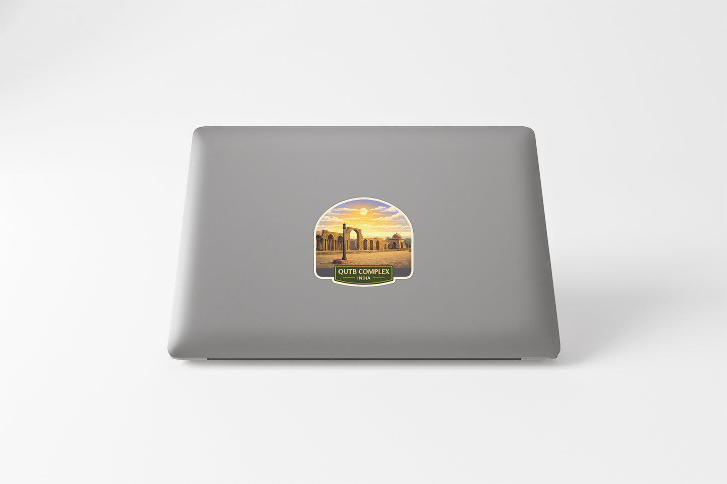 a sticker on the back of a laptop, depicting a sunset over a cityscape.