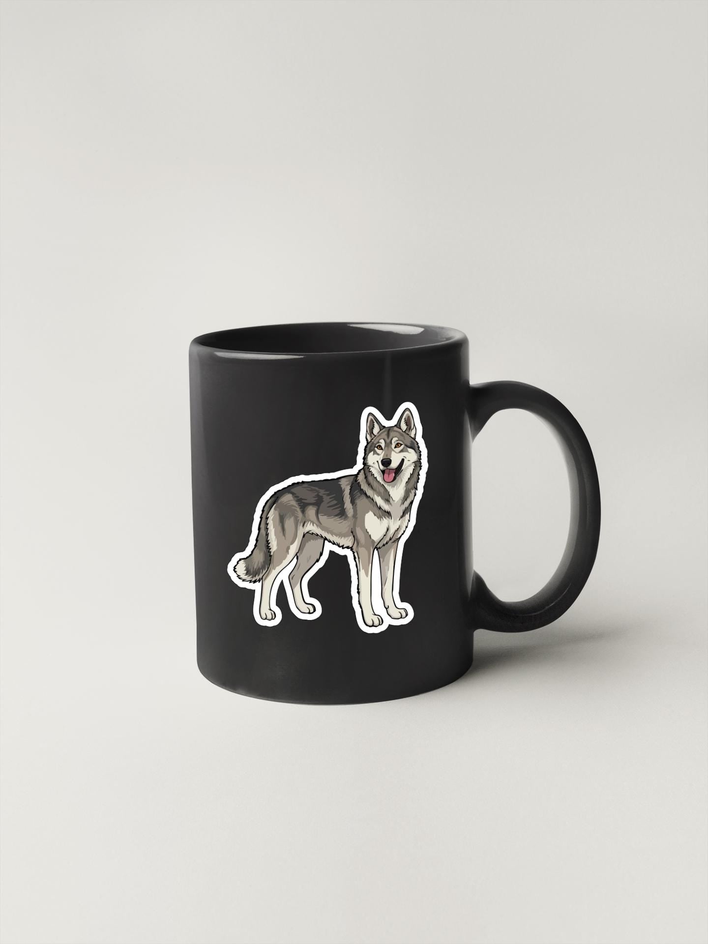A black coffee mug with a sticker of a wolf or husky dog on it.
