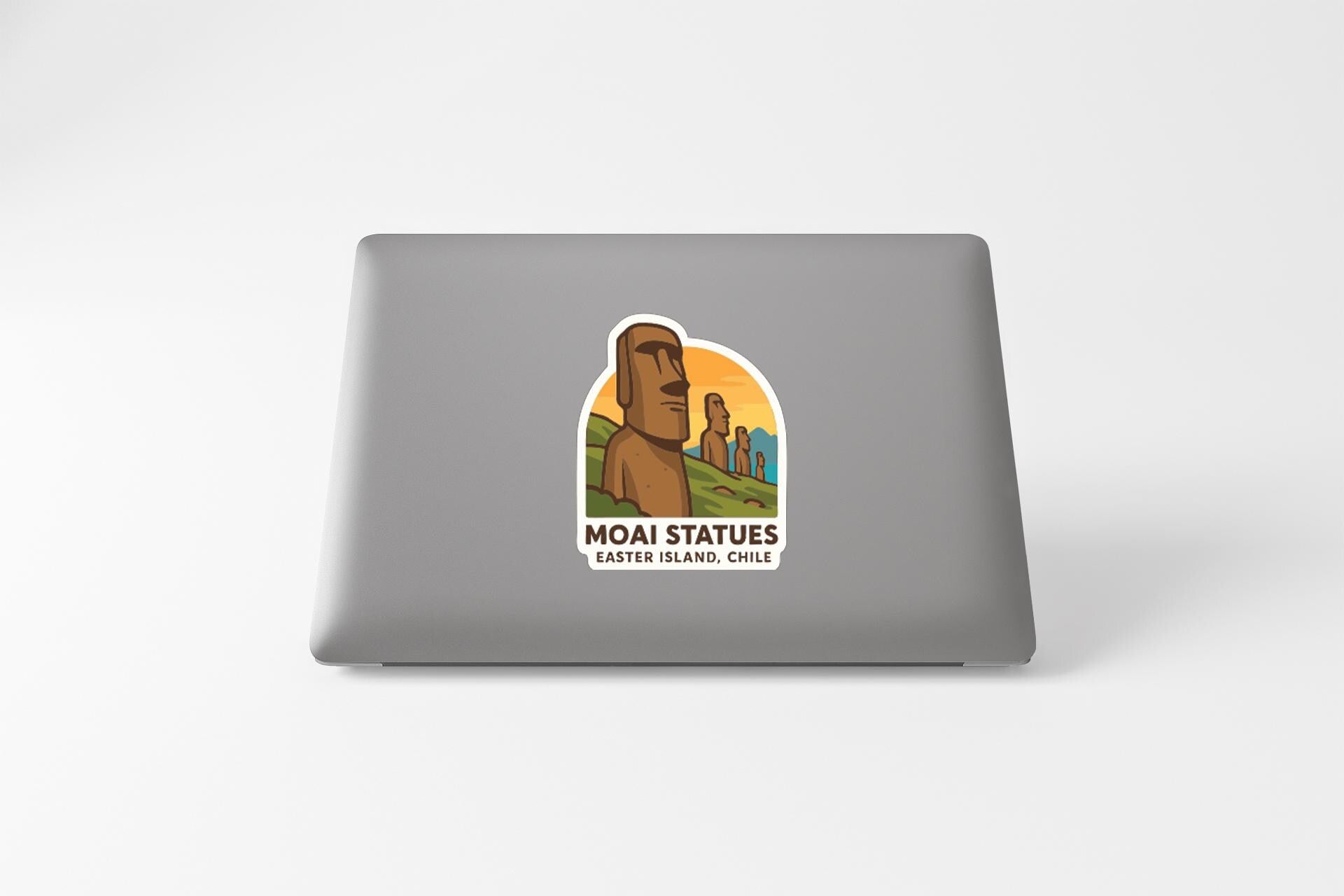 a sticker with an illustration of Moai statues on a laptop.