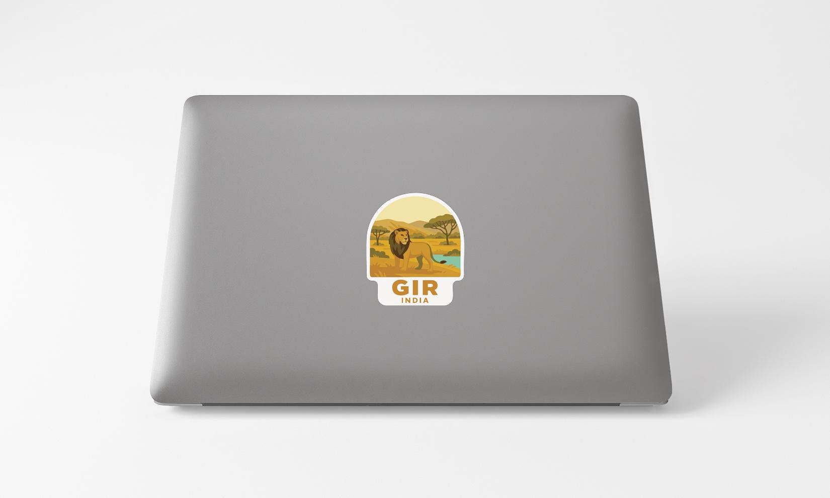 a sticker with a lion and the word "GIR" on the back of a laptop.