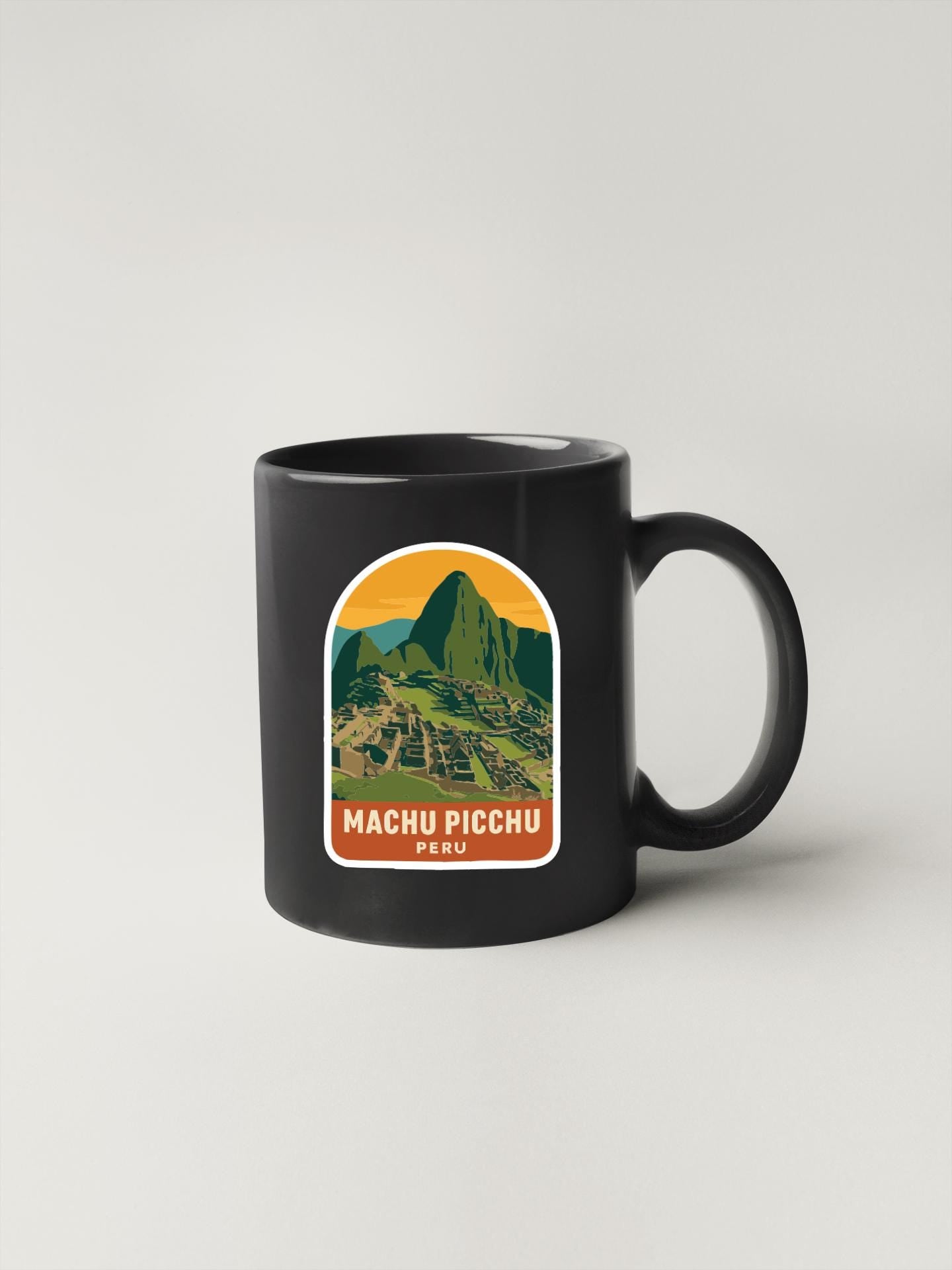 A black coffee mug with a graphic of Machu Picchu, a famous Incan citadel, and the text "MACHU PICCHU PERU" printed on it.