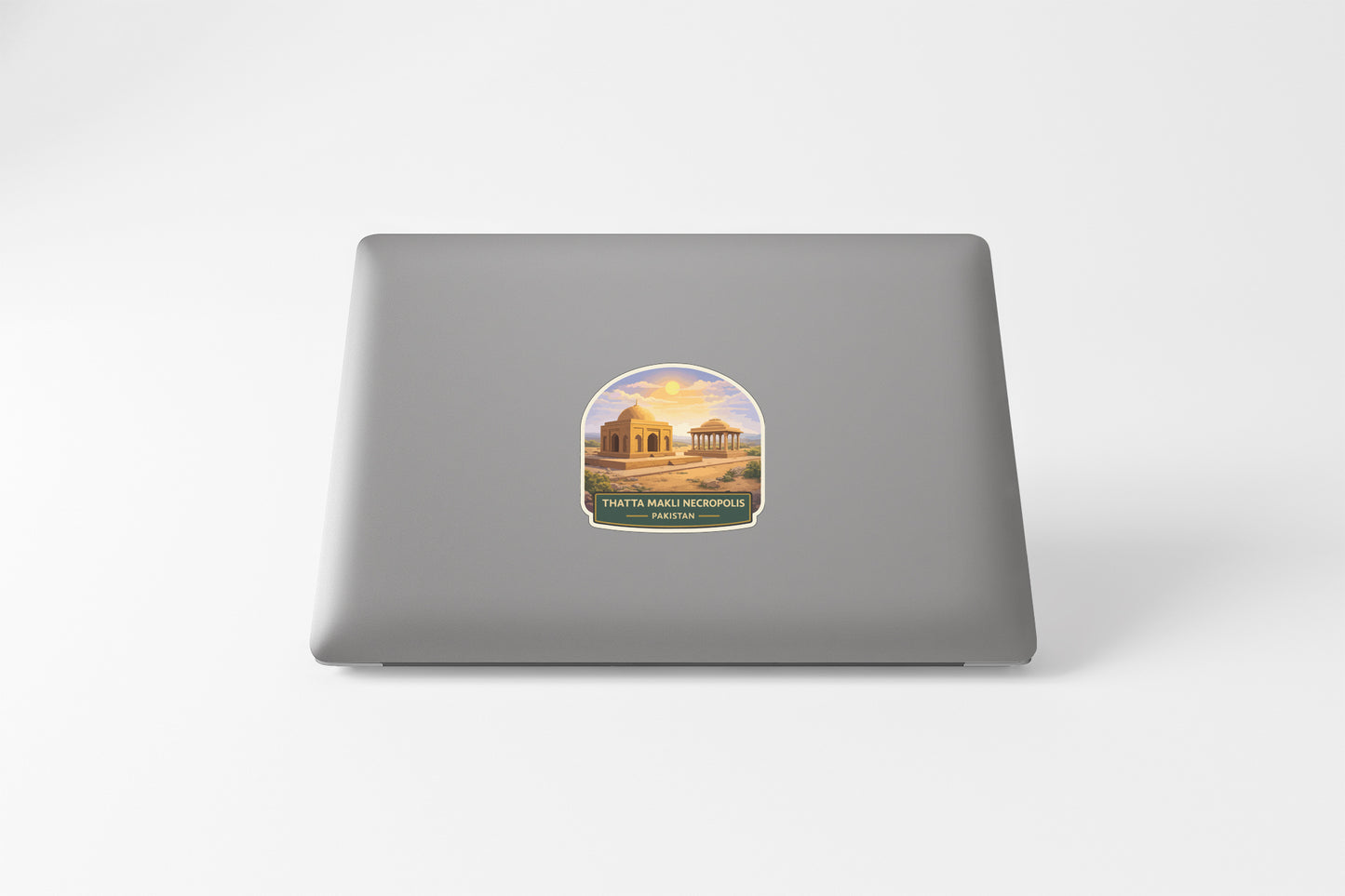 a sticker on the back of a laptop, depicting a scenic landscape with a temple in the background.
